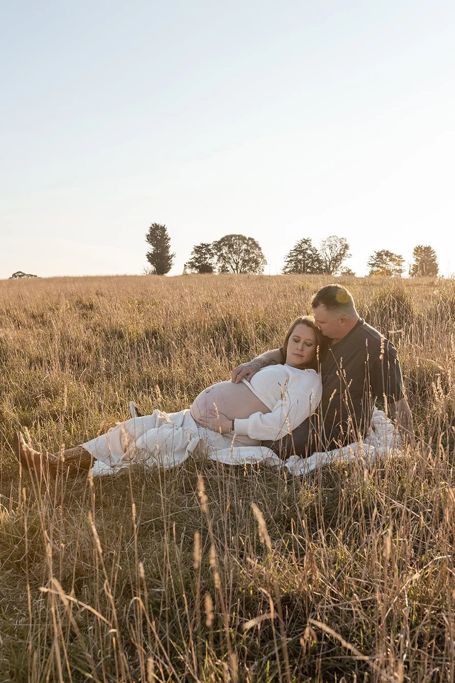 Couple sitting in long grace embracing during maternity photoshoot in Melbourne's North East