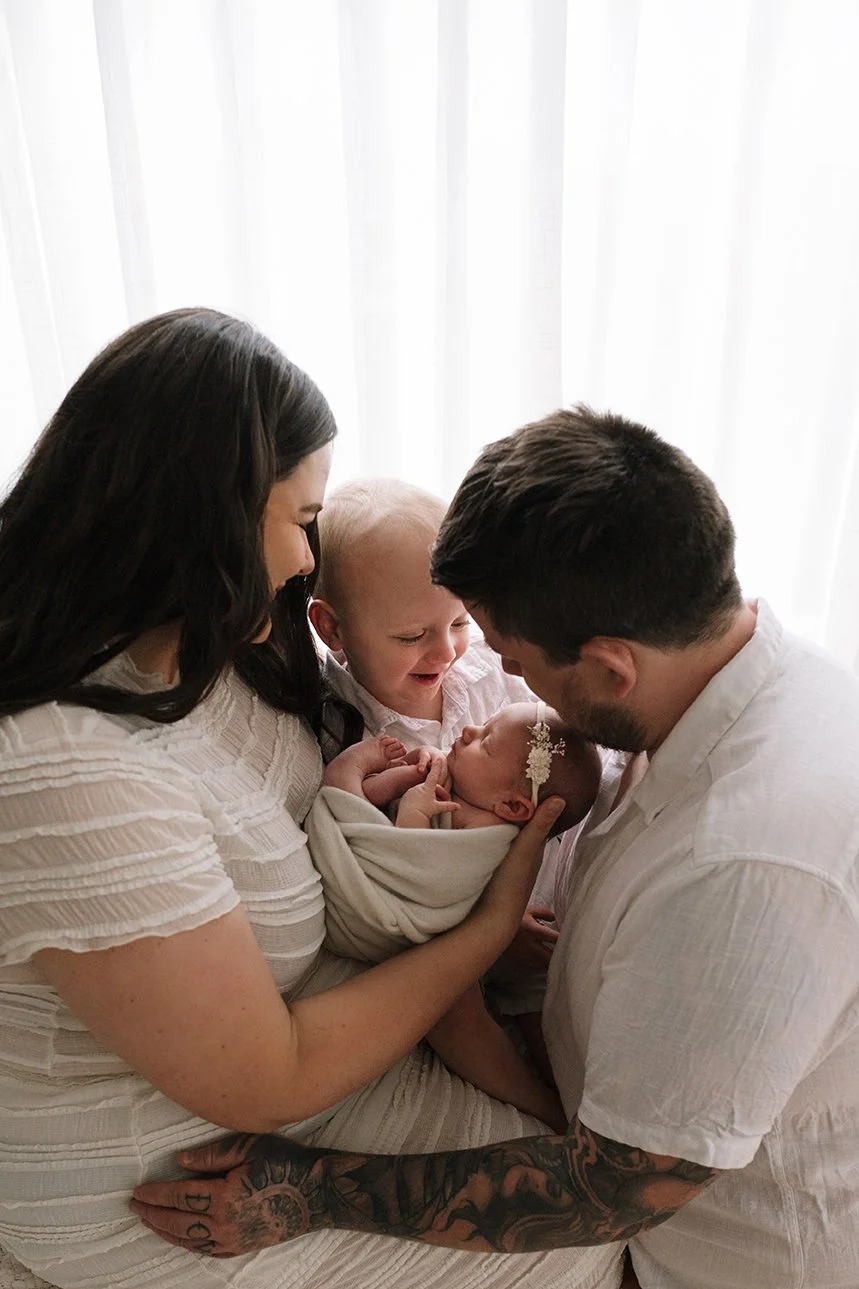 Growing family photographed with their newborn baby.
