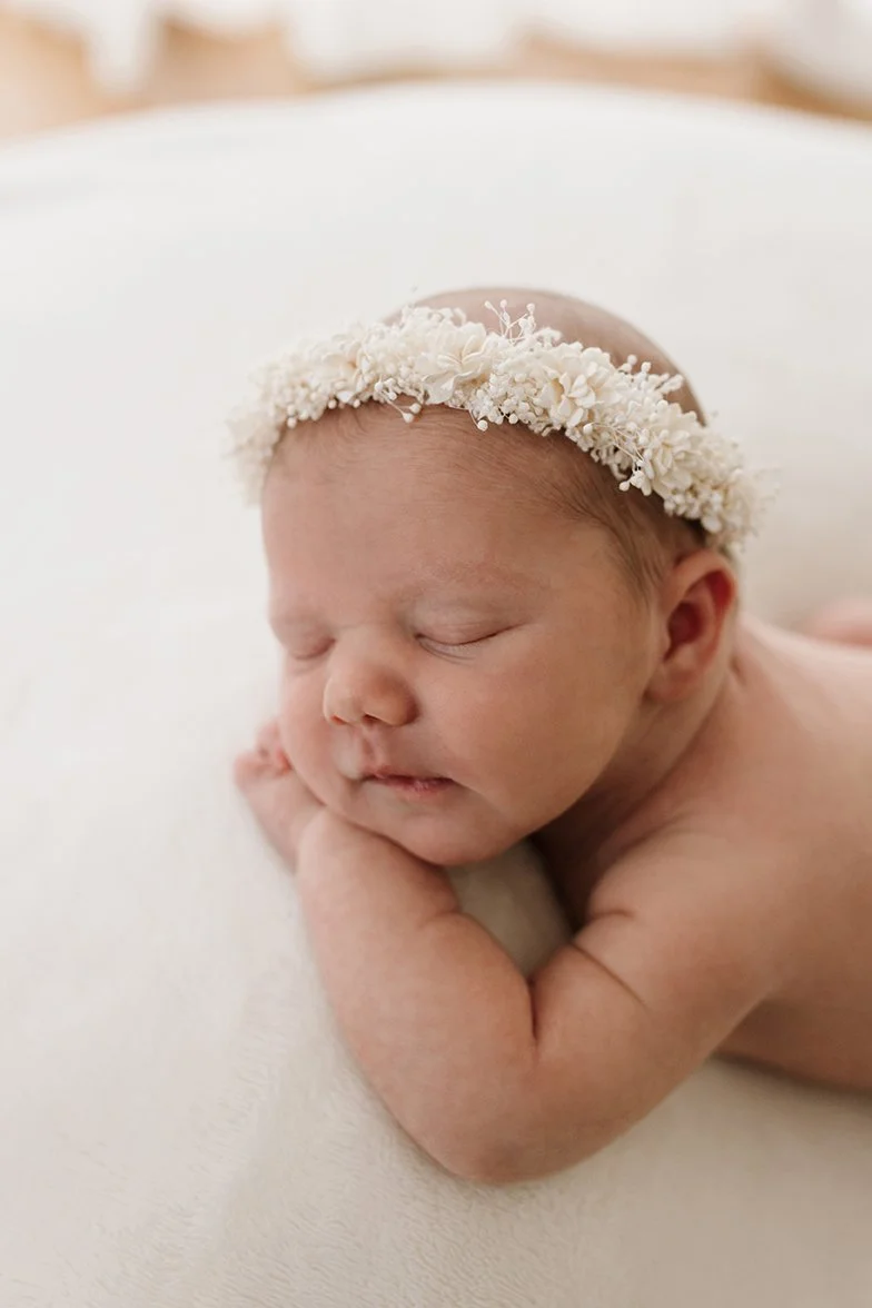 Newborn baby sleeping peacefully on soft white blanket 