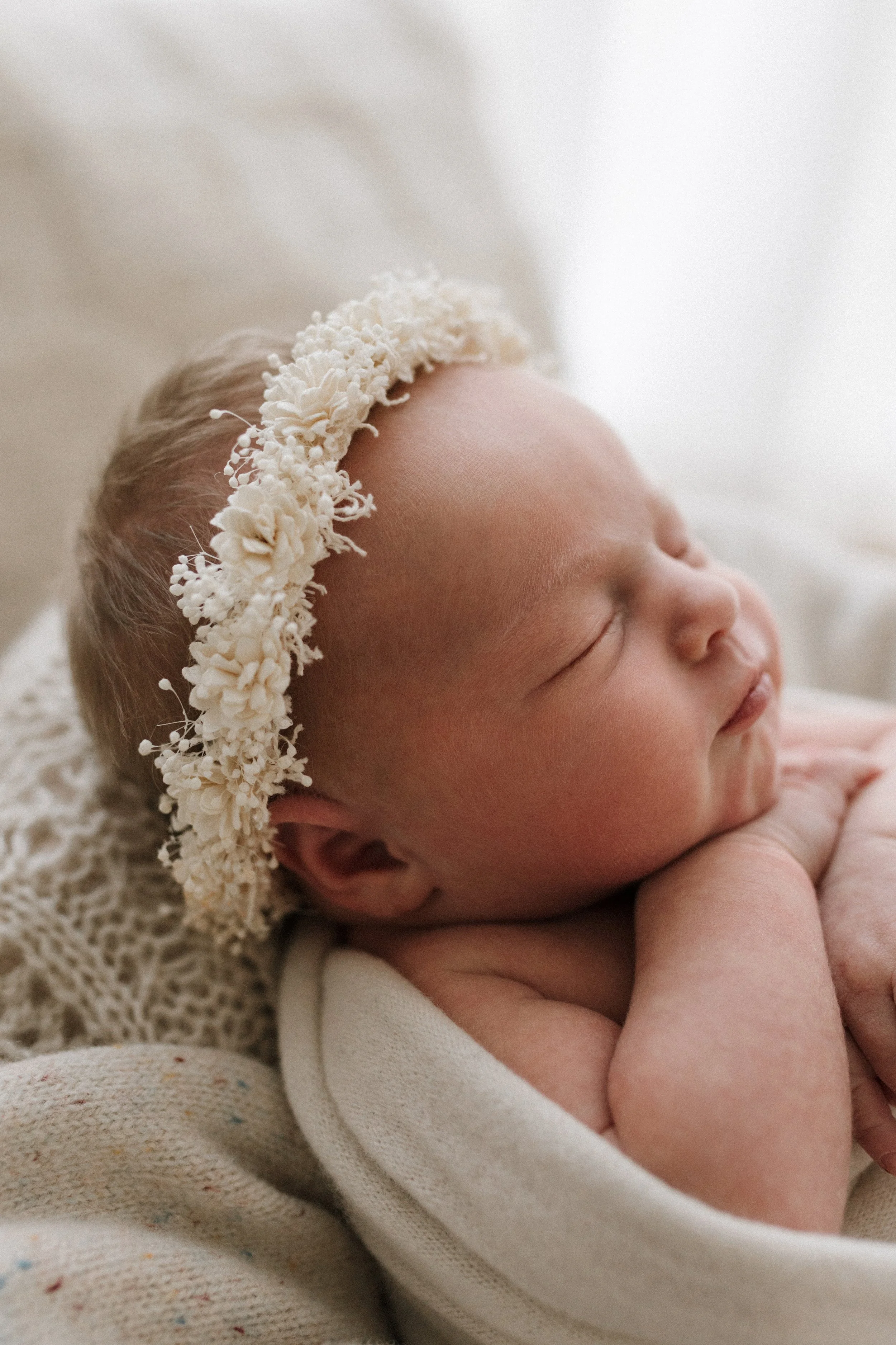 Newborn baby swaddled and sleeping in a basket