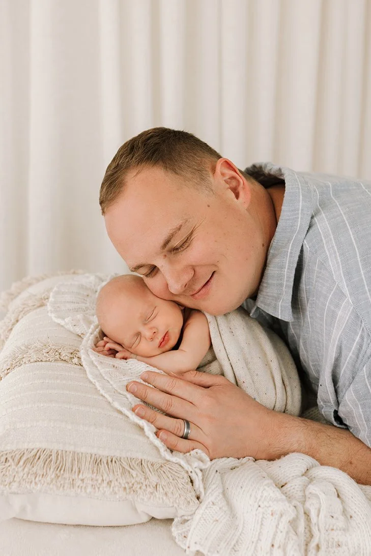 Tender portrait of a father and newborn baby together.