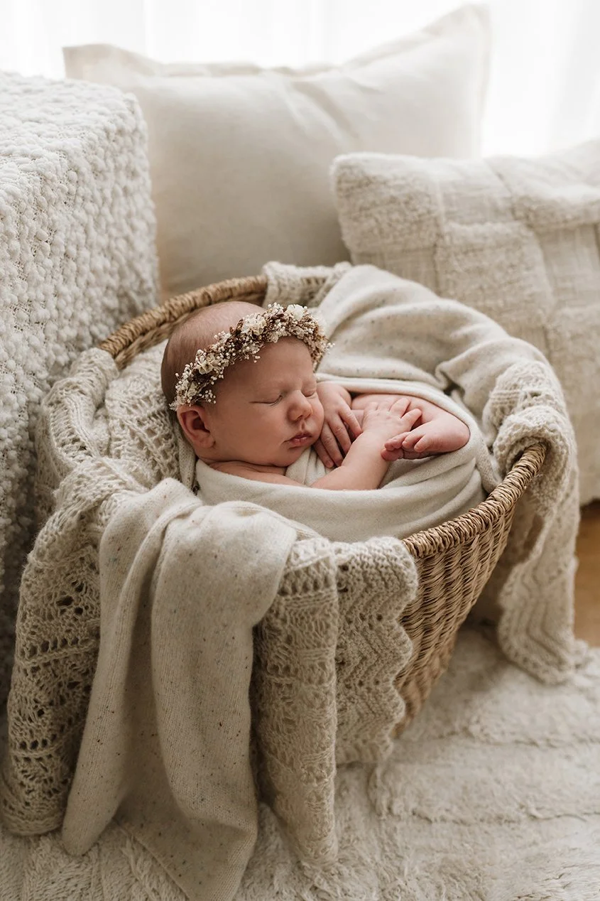Newborn baby swaddled and sleeping in a wicker basket