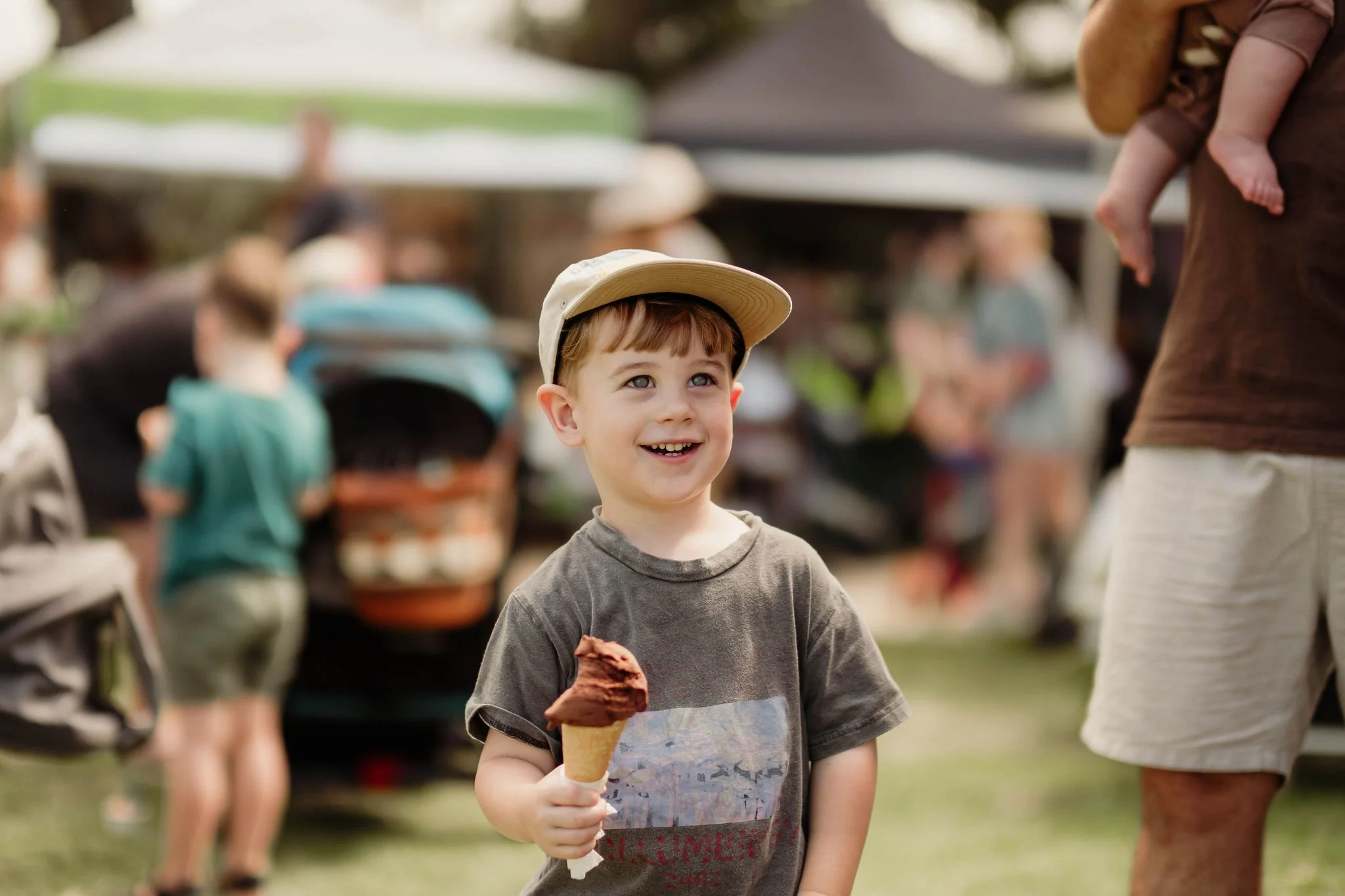 Happy boy eating chocolate gelato at a market