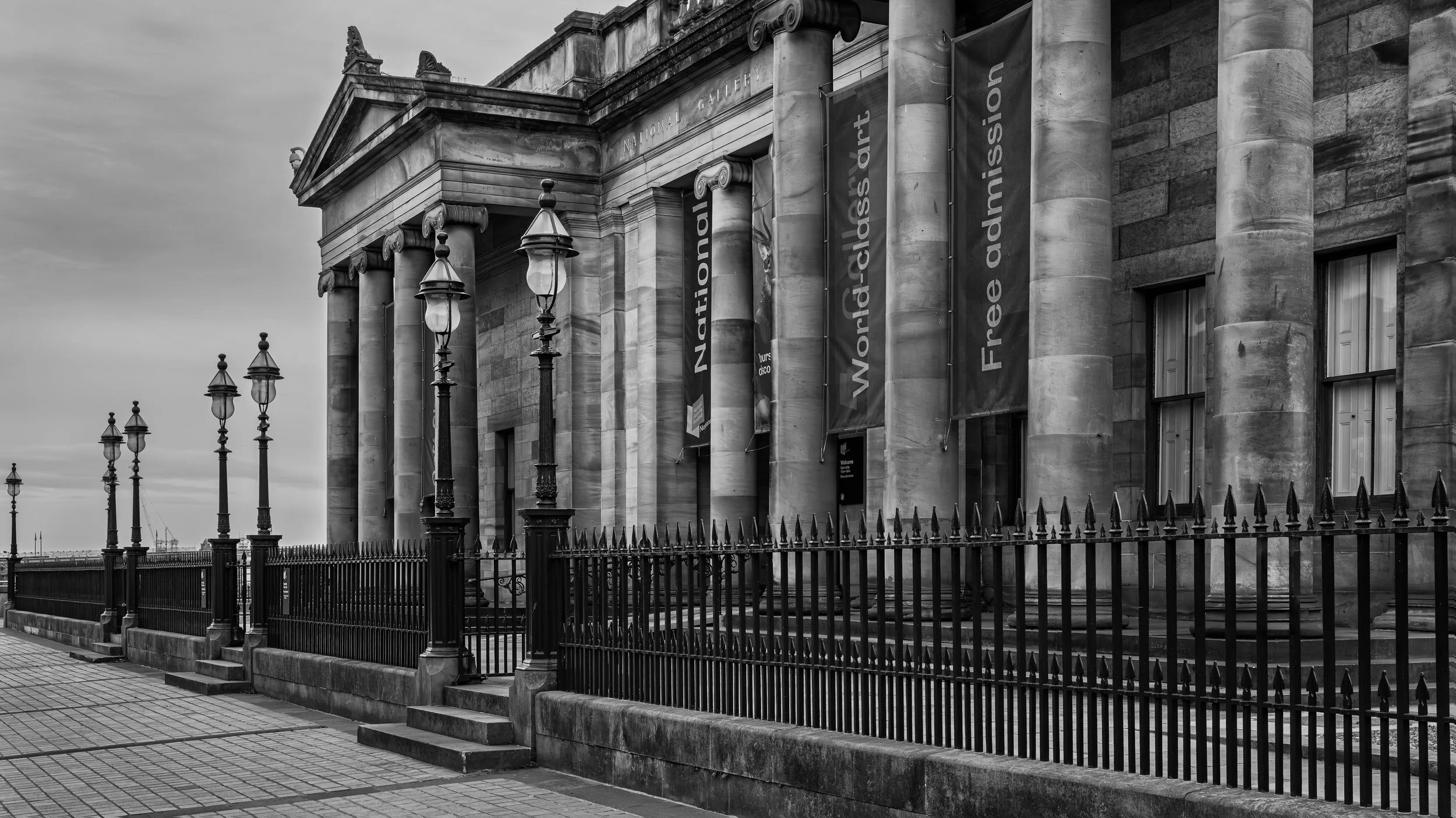 Exterior of the National Gallery building with columns and banners, black and white photograph.