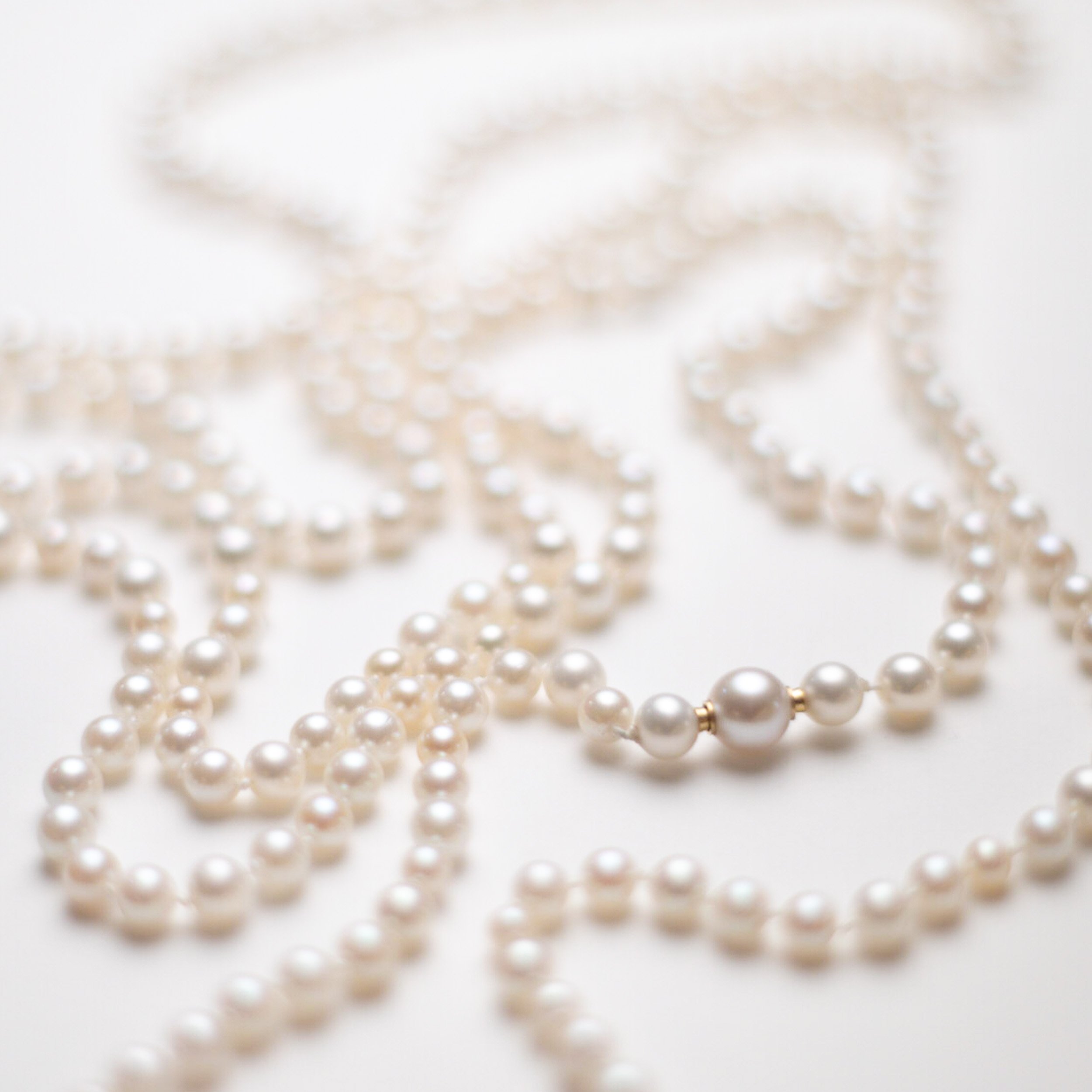 170 cm long pearl necklace crafted from various pearl strands, carefully combined into one continuous string. Made with silk thread and knotted between each pearl. The design features a new large, single pearl with a hidden 18k gold clasp. The neckla