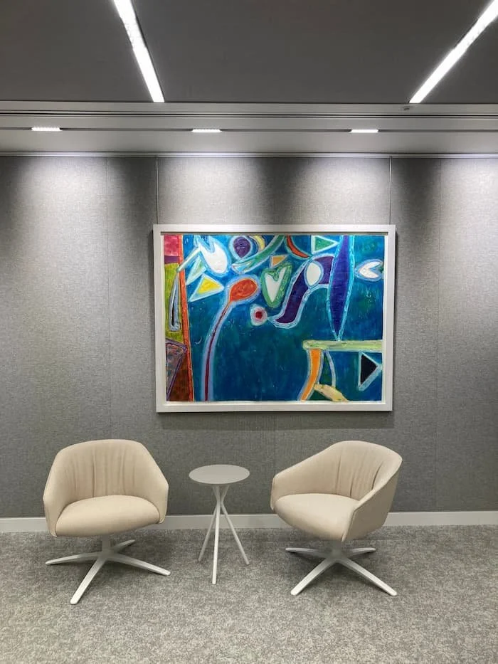 Gallery-trained technician using a laser level and specialist picture rail system to  ensure a precise, museum-standard picture hanging installation in London.