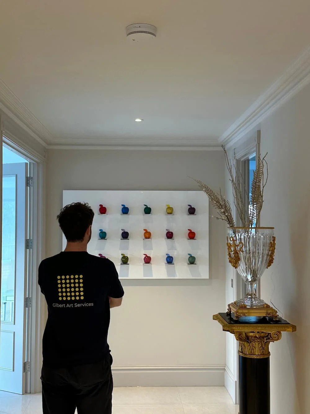 Gilbert art services professionally installing a wall mounted sculpture in a period surrey home
