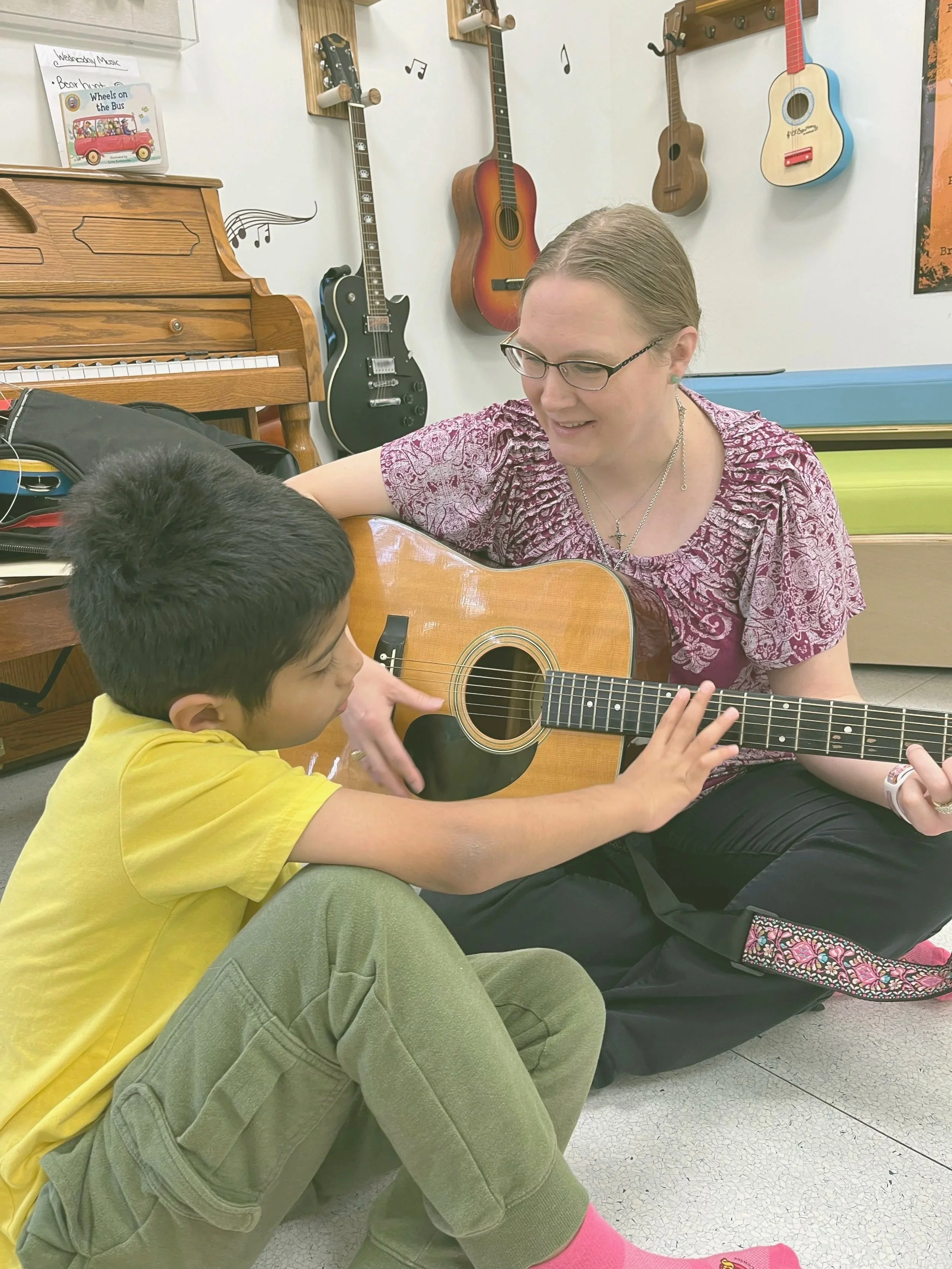 Lady playing guitar with child