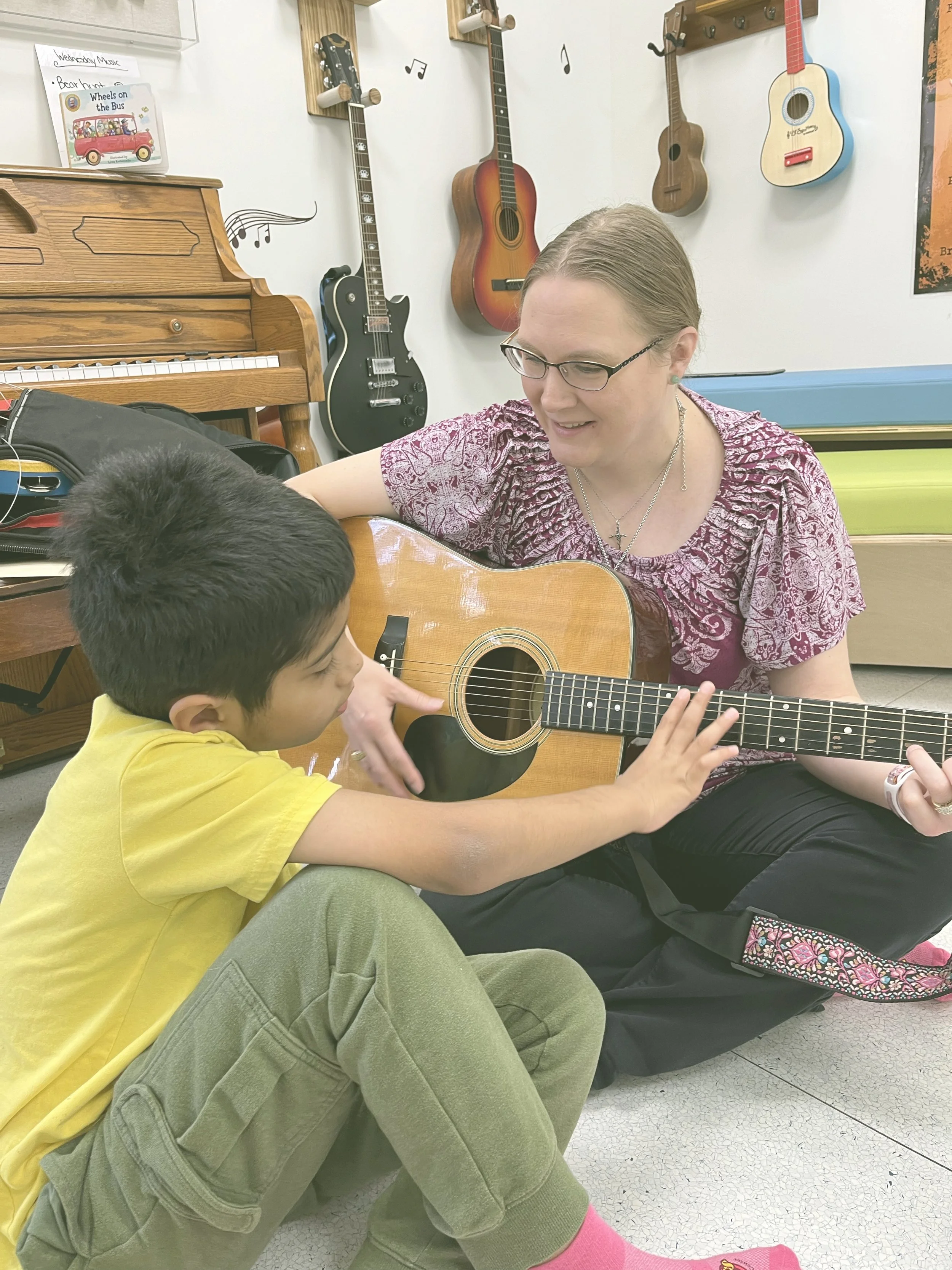 Lady playing guitar with child