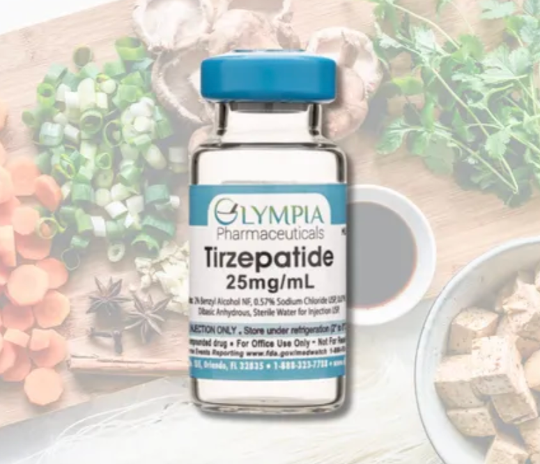 A medical vial of Tirzepatide 25 mg/mL from Olympia Pharmaceuticals on a wooden surface, surrounded by fresh ingredients and herbs.