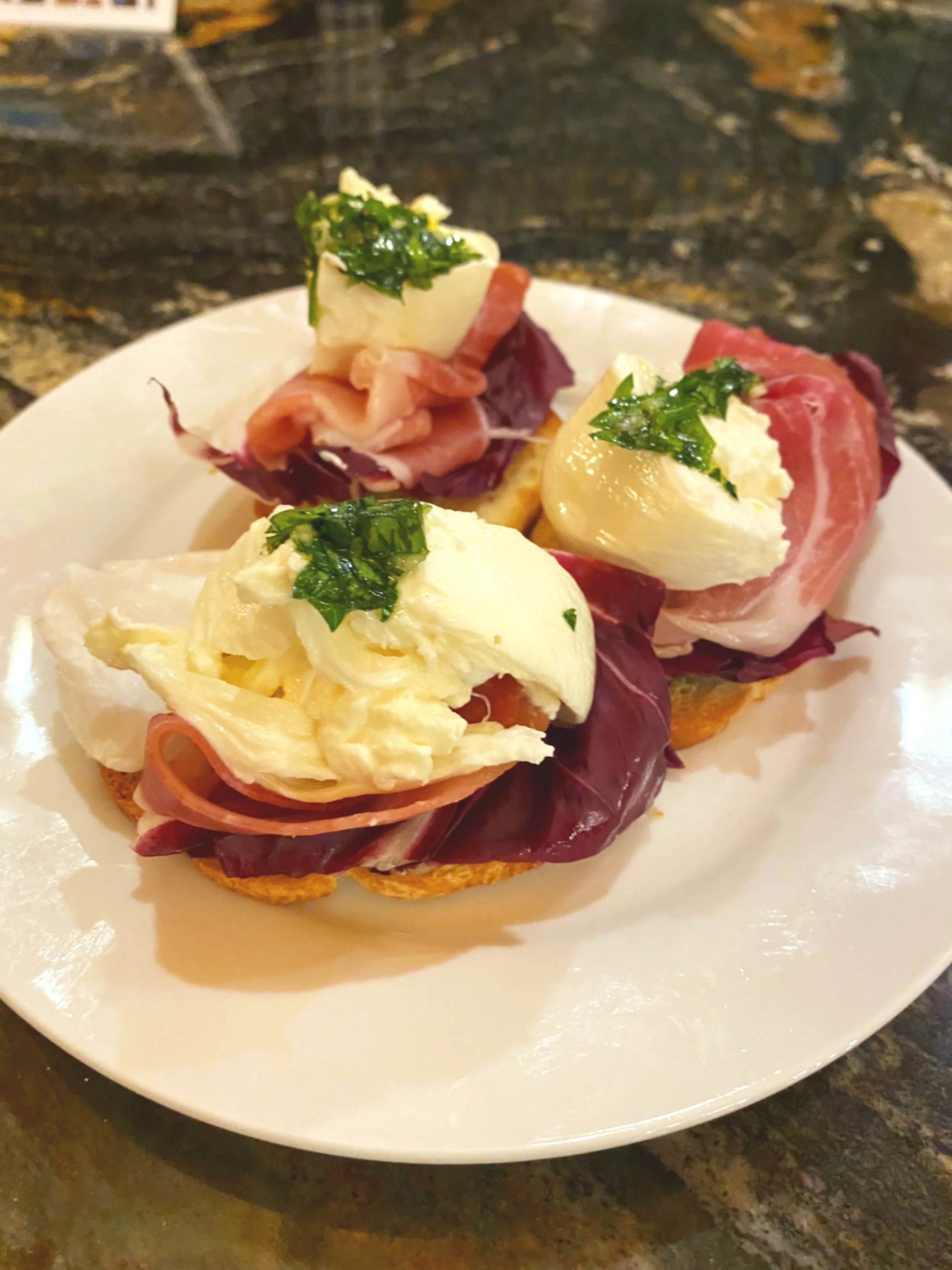 Open-faced sandwiches with sliced meats, cheese, lettuce, and green herbs on toasted bread at Bettina Cafe Phoenicia NY near Catskill Mountains