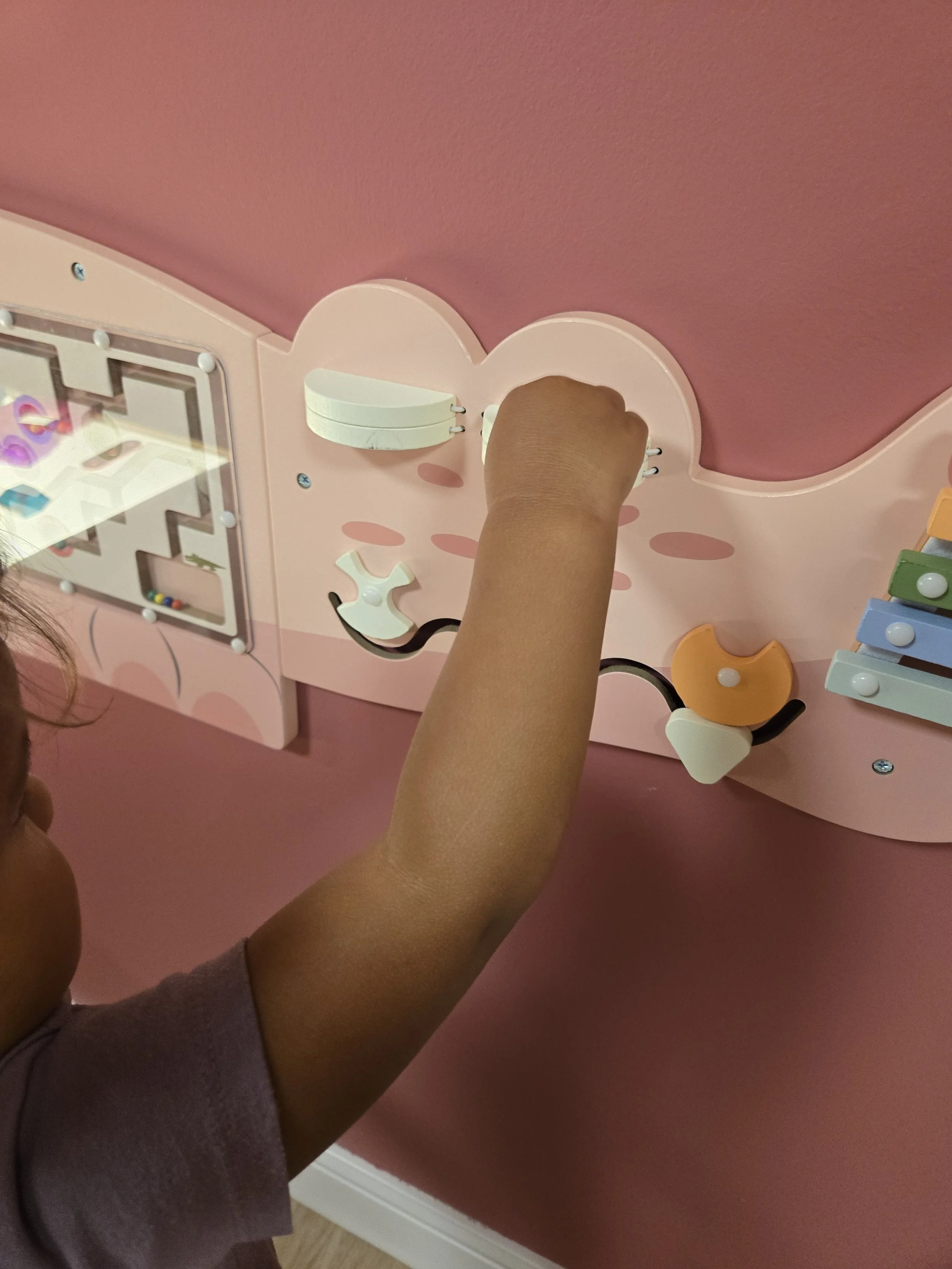 child playing with sensory wall