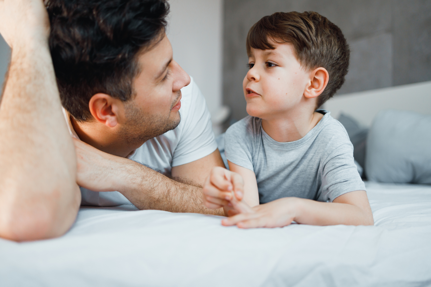 A school-age boy practicing sentence building and speech production with his father. This image represents pediatric speech therapy in Arizona focused on helping 4 and 5-year-olds expand from single words to full phrases for kindergarten readiness.