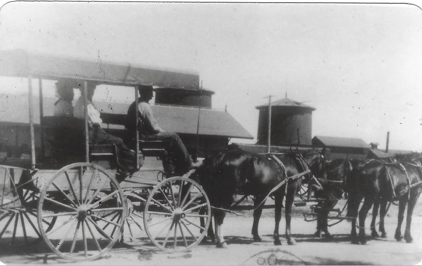 An old photograph of the horse-drawn Parkfield stagecoach headed to San Miguel with three rows of horses and passengers seated on the upper level, set in Parkfield, California in 1906 with buildings.