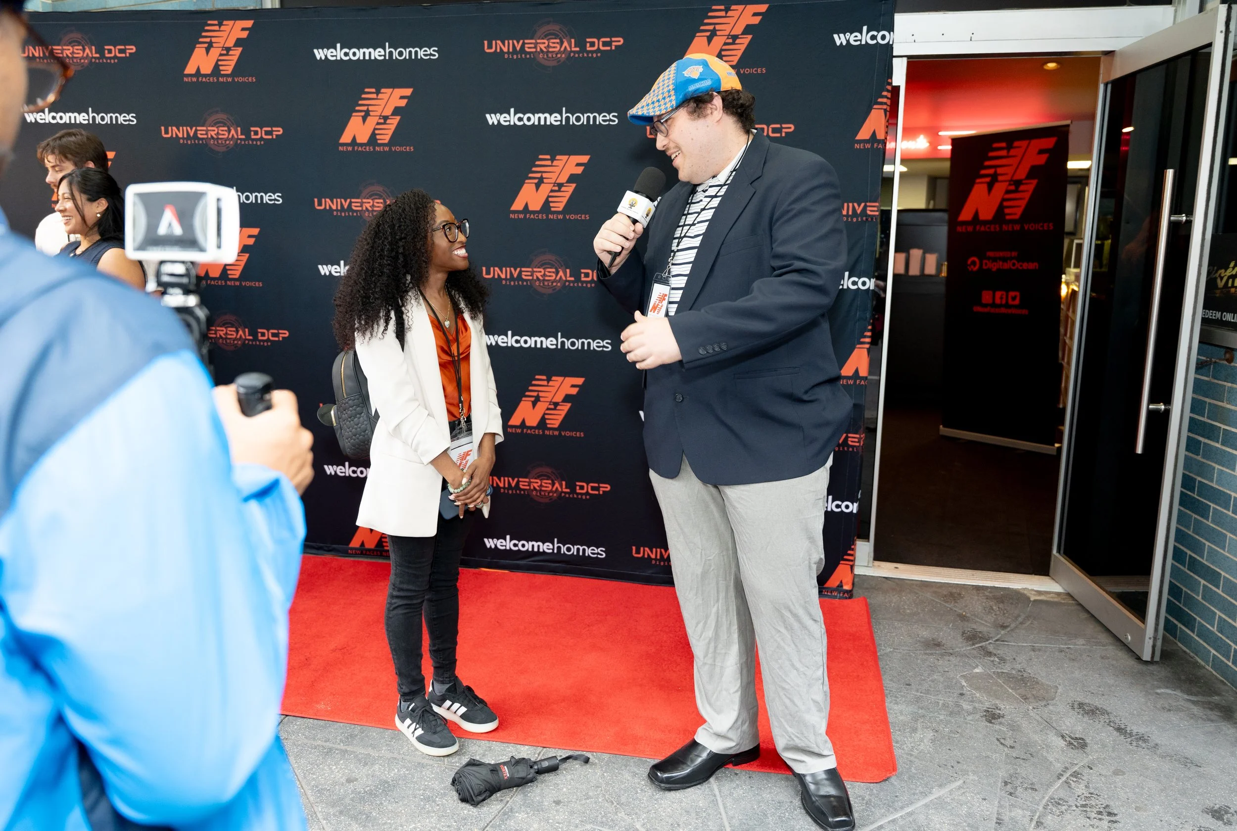 Asia Gordon conducting a filmmaker interview on the red carpet at the New Faces New Voices Film Festival.