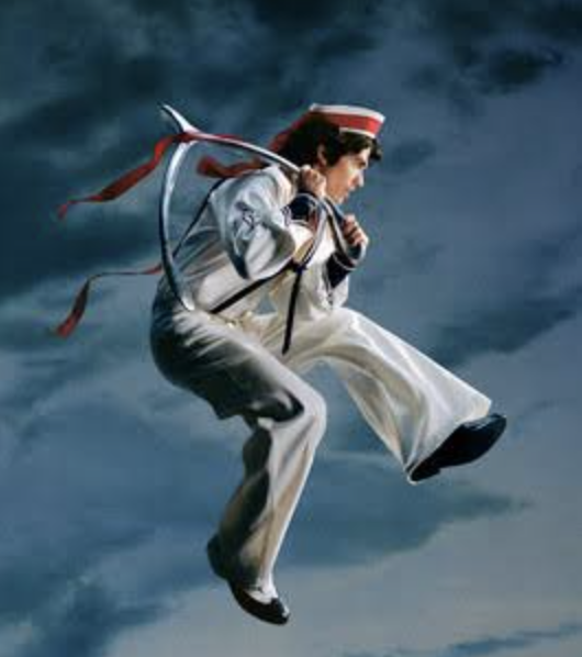 A person dressed as a sailor or navy officer, dressed in white uniform and hat, appears to be floating or jumping in mid-air against a cloudy sky background.