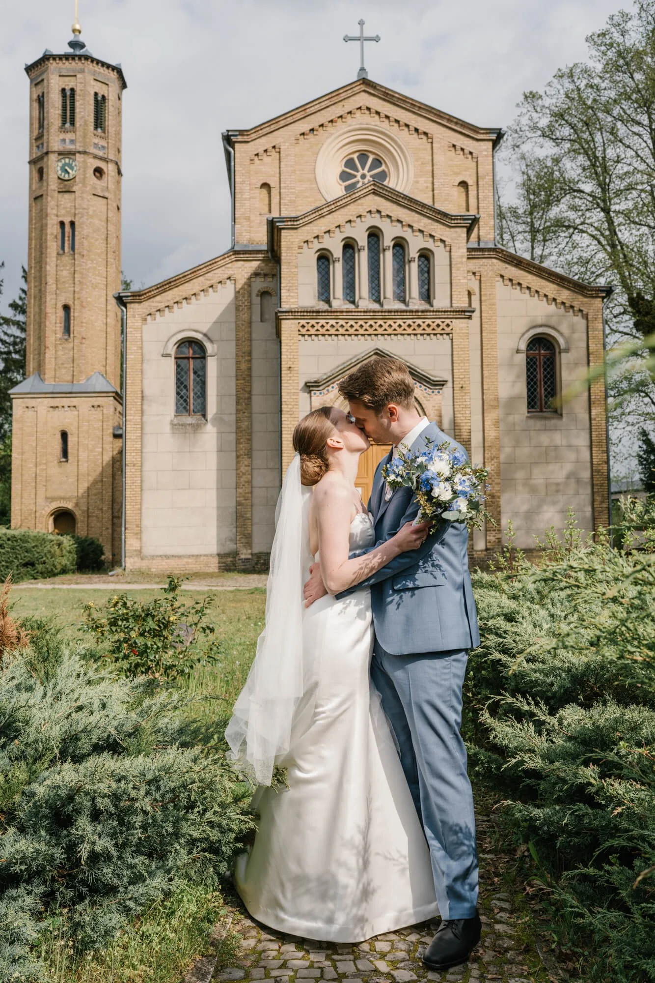 wedding couple kissing in front of Dorfkirche Caputh