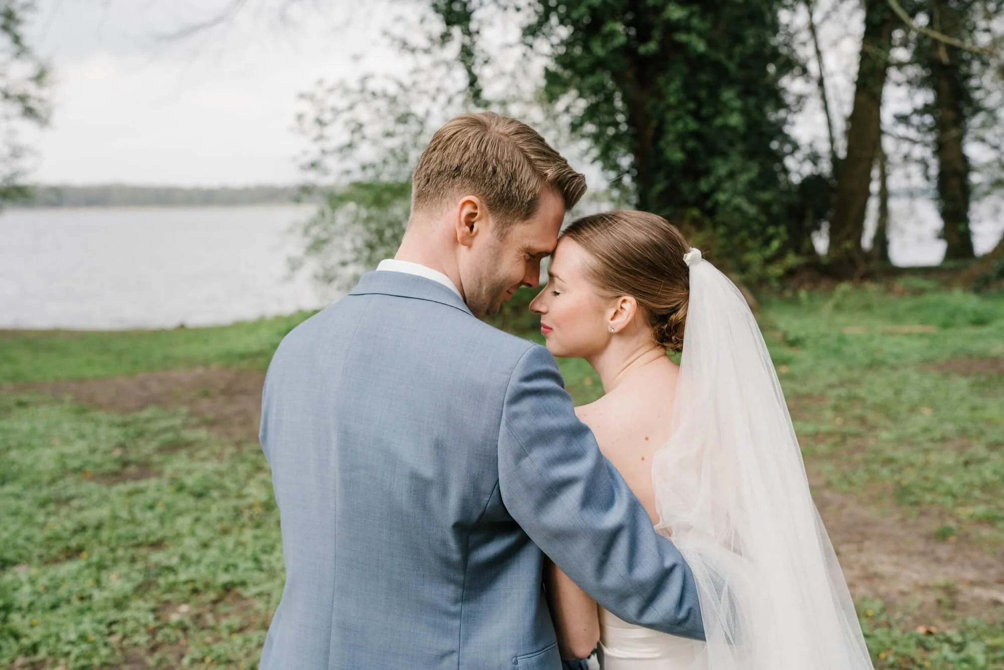 wedding couple sitting in park Caputh from the back