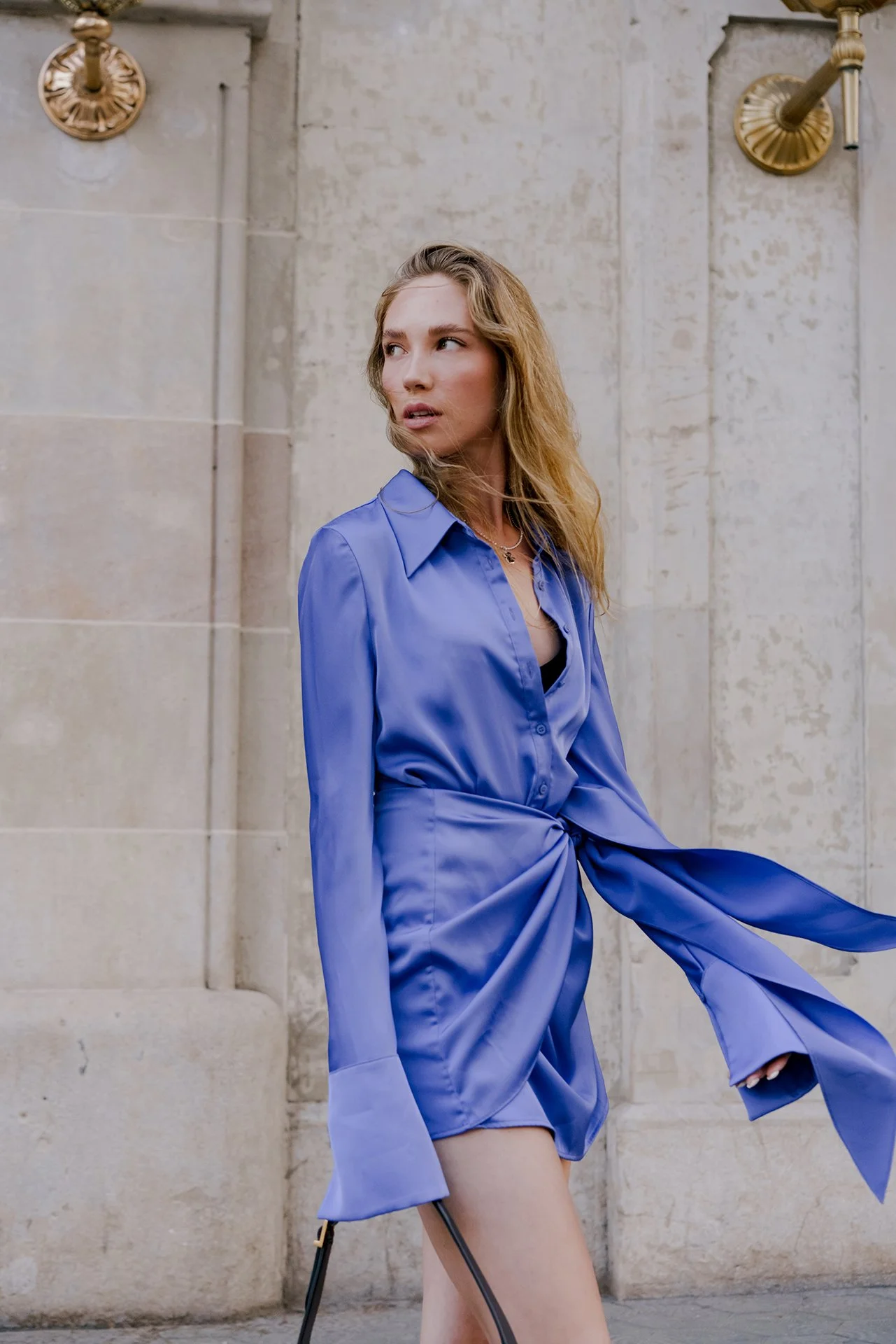 Model is wearing Lila dress with wind on the streets posing for portrait photographer in Milan for model shoots
