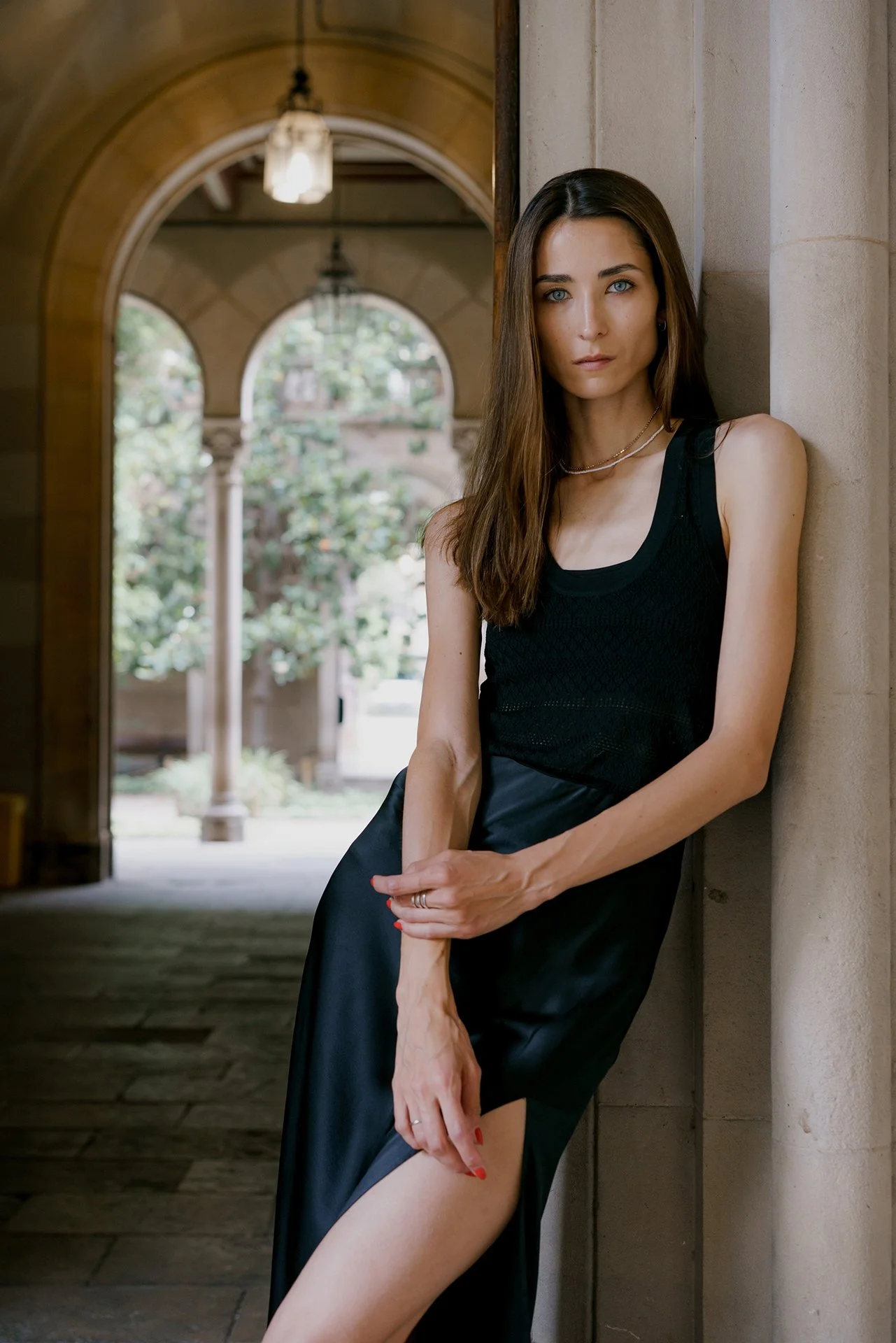 Portrait of a model in beautiful architecture of Milan city in a black dress posing for photographer