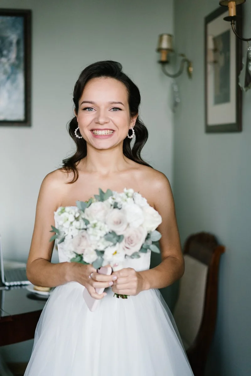 Happy bride is holding her bouquet during wedding morning in Munich