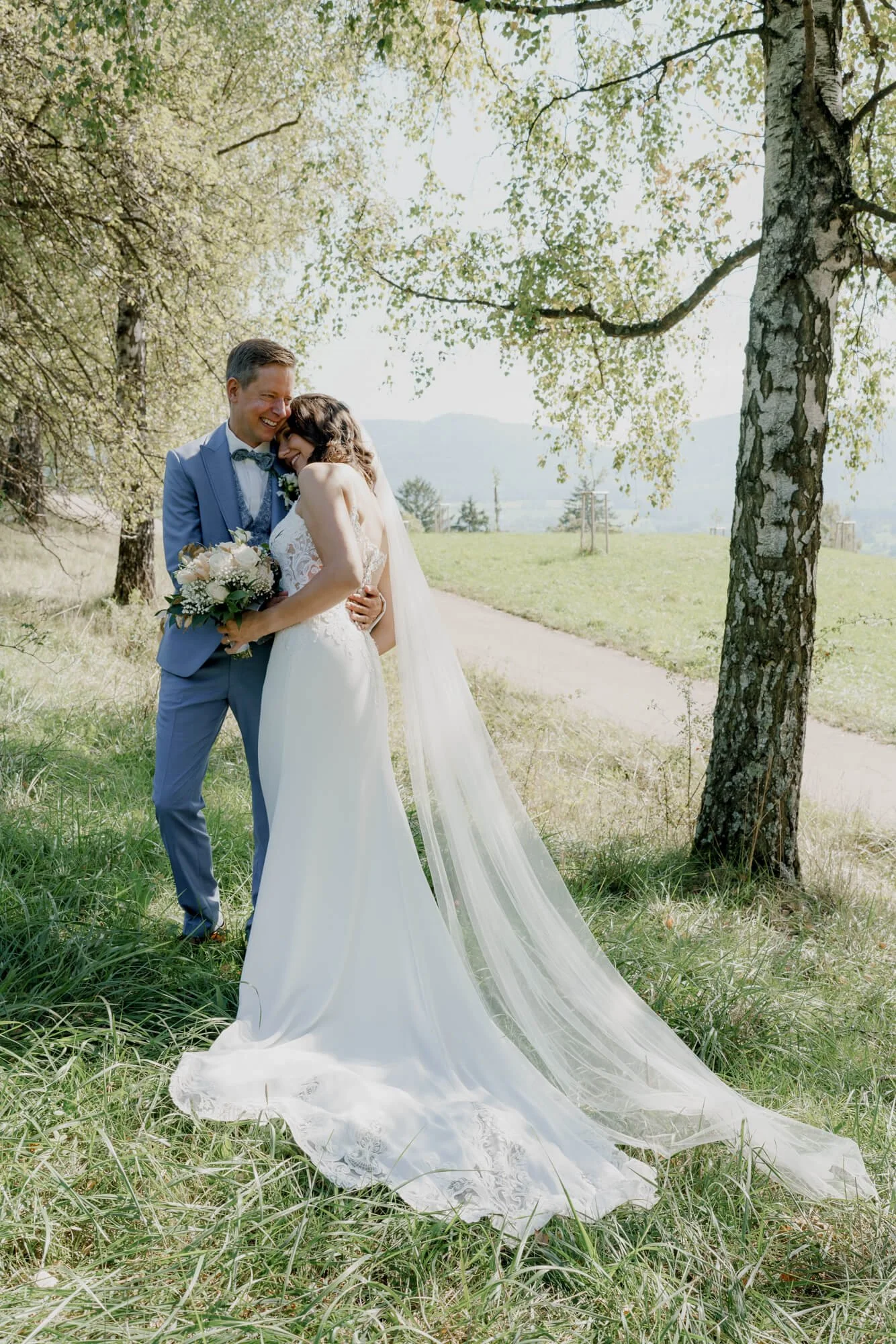 Bride is laying on her husband shoulder during wedding photosession in Stuttgart