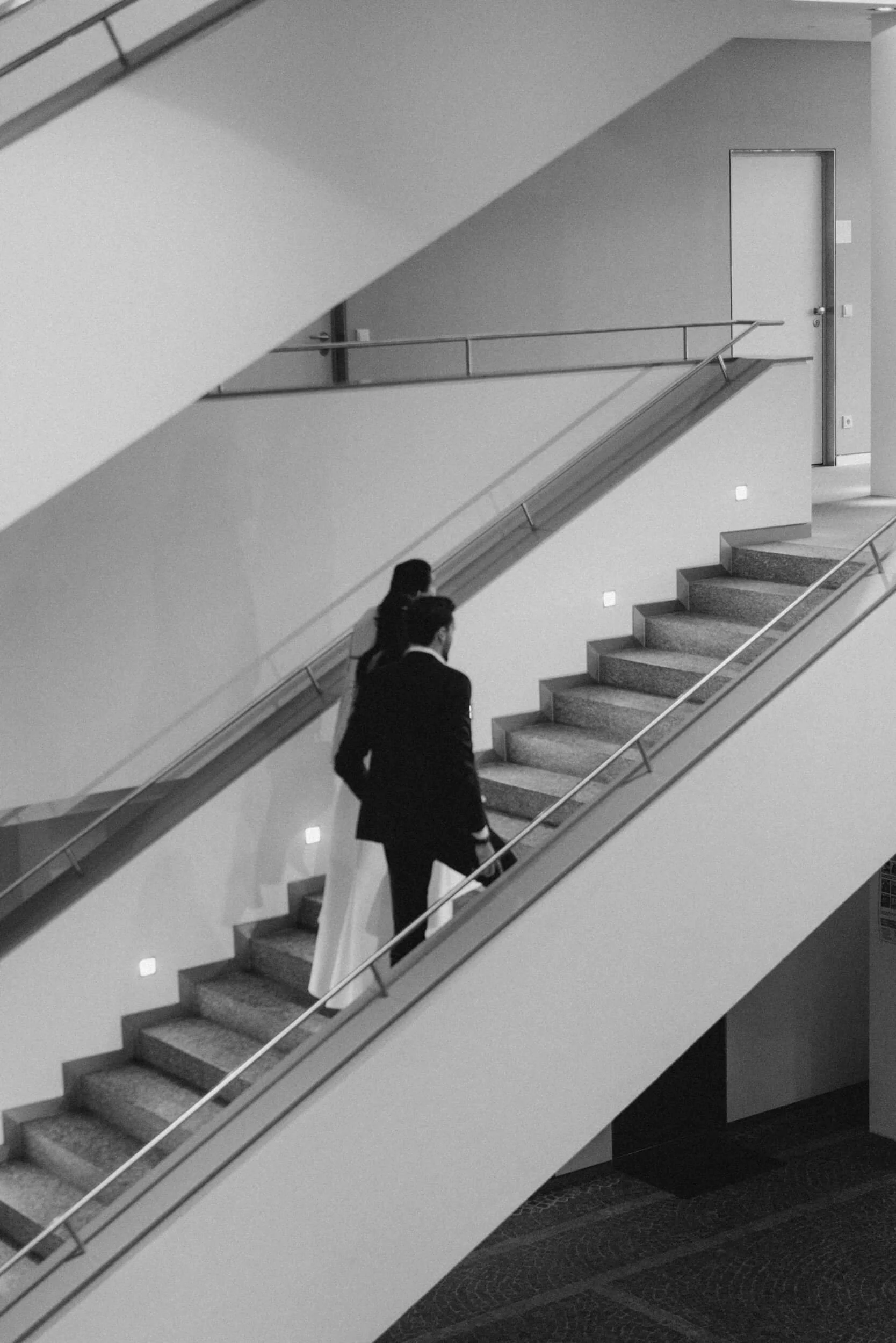 couple go up the stairs in Standesamt Grünwald
