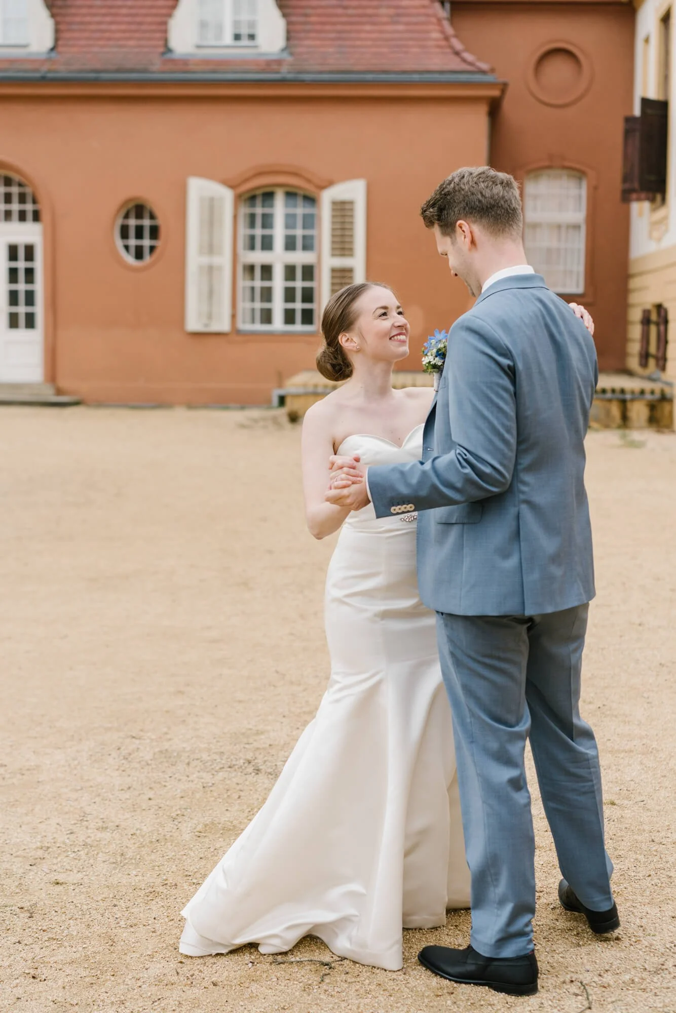 wedding couple is dancing with Schloss Caputh in the background