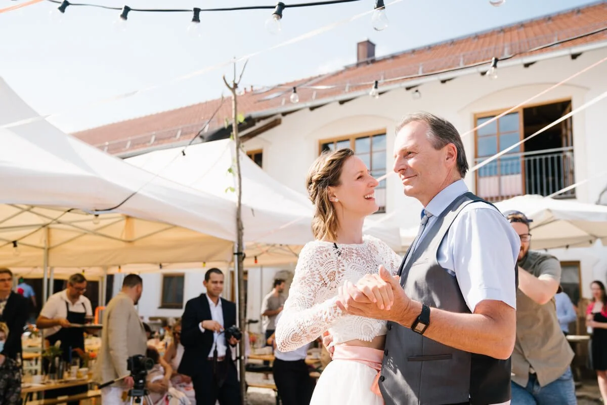 Wedding celebration in wedding venue Seminarhof Lamplstätt in Munich area. Bride is dancing with her father