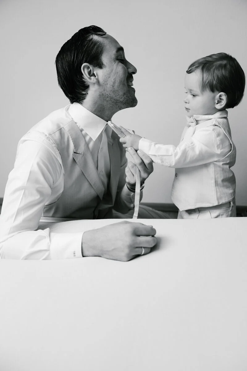 Small kid is helping his father on the wedding day in preparation