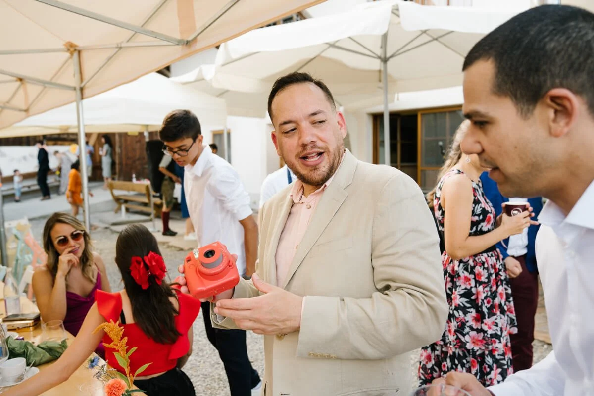 Wedding guests are taking photos with instant camera during Wedding celebration in wedding venue Seminarhof Lamplstätt in Munich area