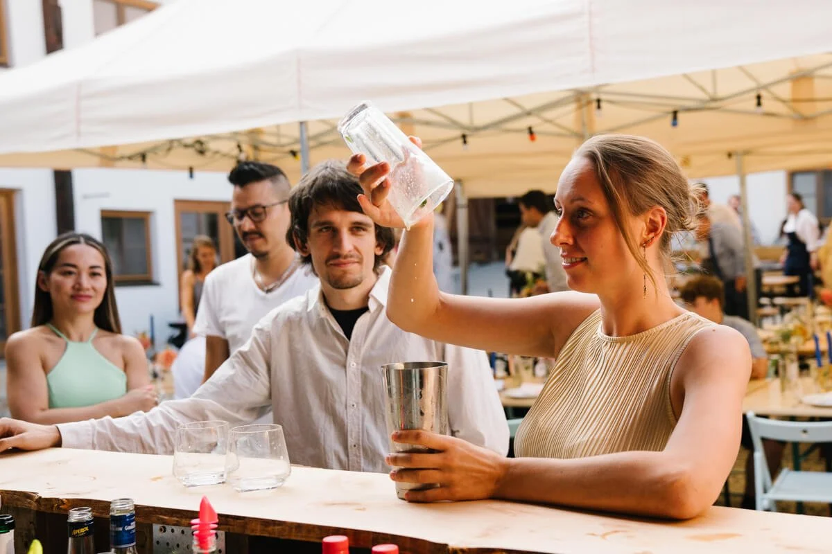 Guests are making cocktails during wedding celebration in wedding venue Seminarhof Lamplstätt in Munich area