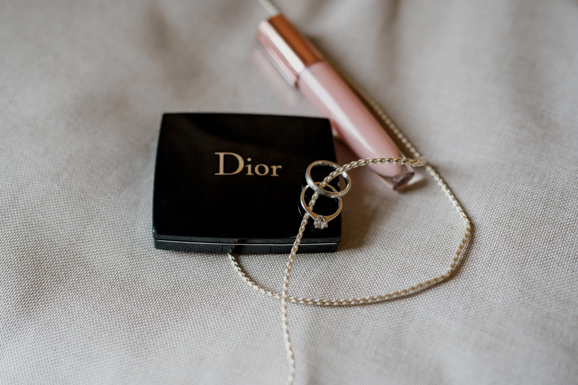 Engagement ring together with wedding rings on dior cosmetics