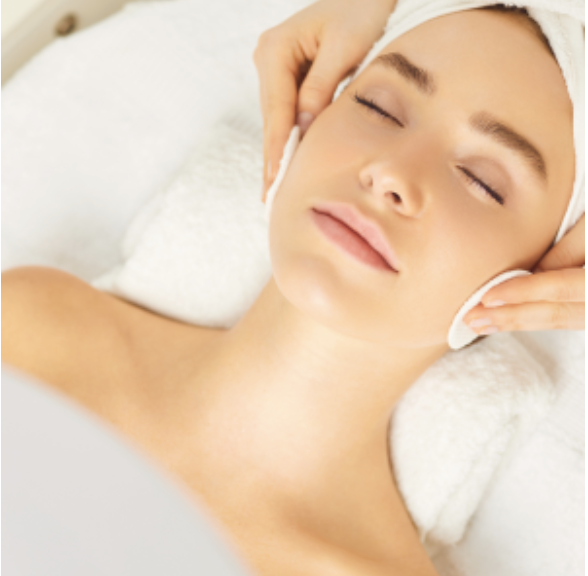 Woman receiving a relaxing facial massage with eyes closed.