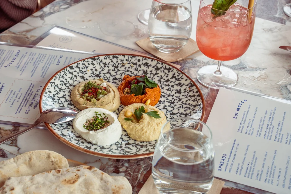Clio spreads with hummus, muhammara, labneh, and warm pita