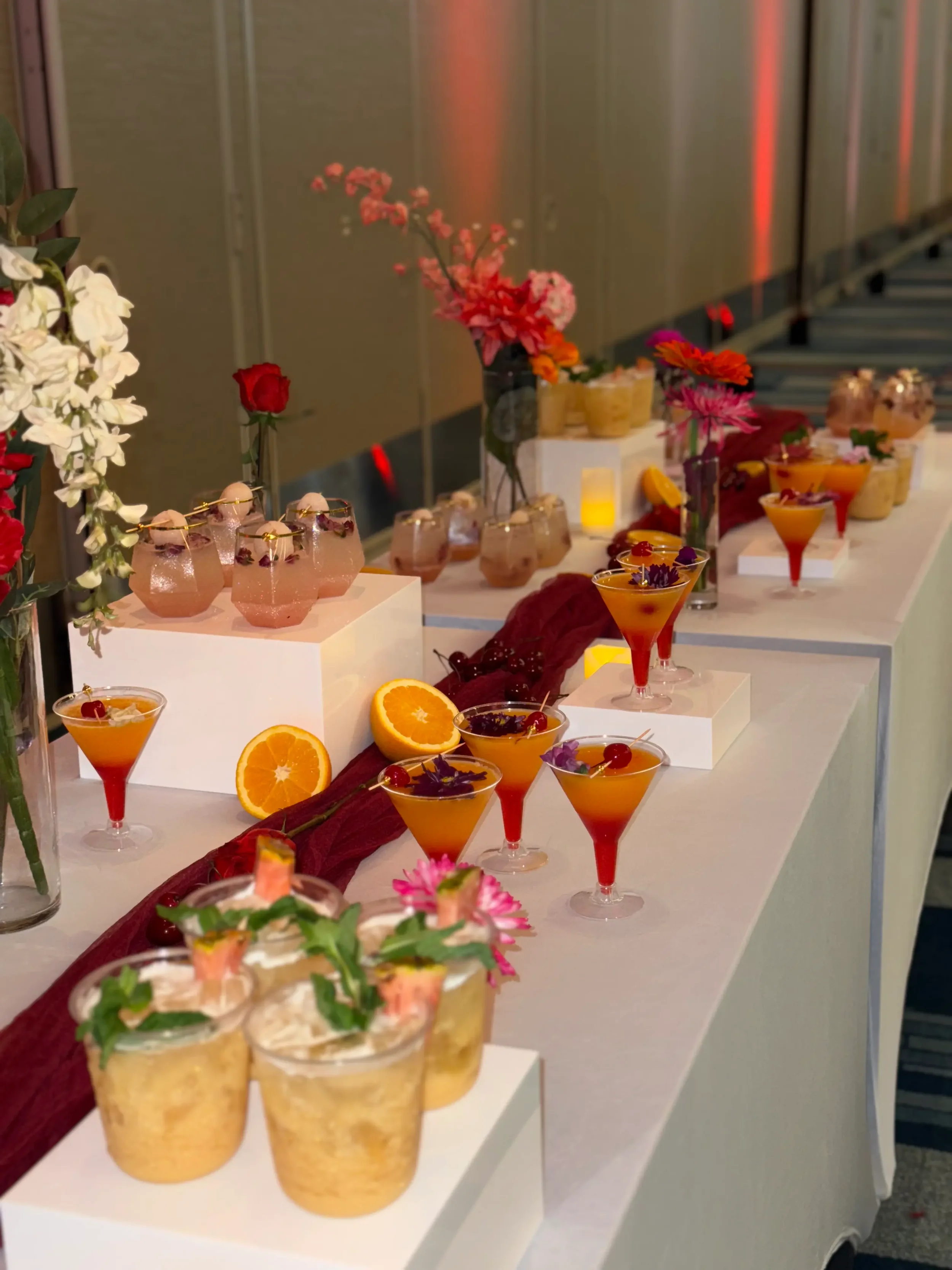 Premium mocktail display with tropical piña colada , Sunrise, lychee mocktails styled on elegant risers as part of Pisco Mixers' luxury mobile bar enhancements.