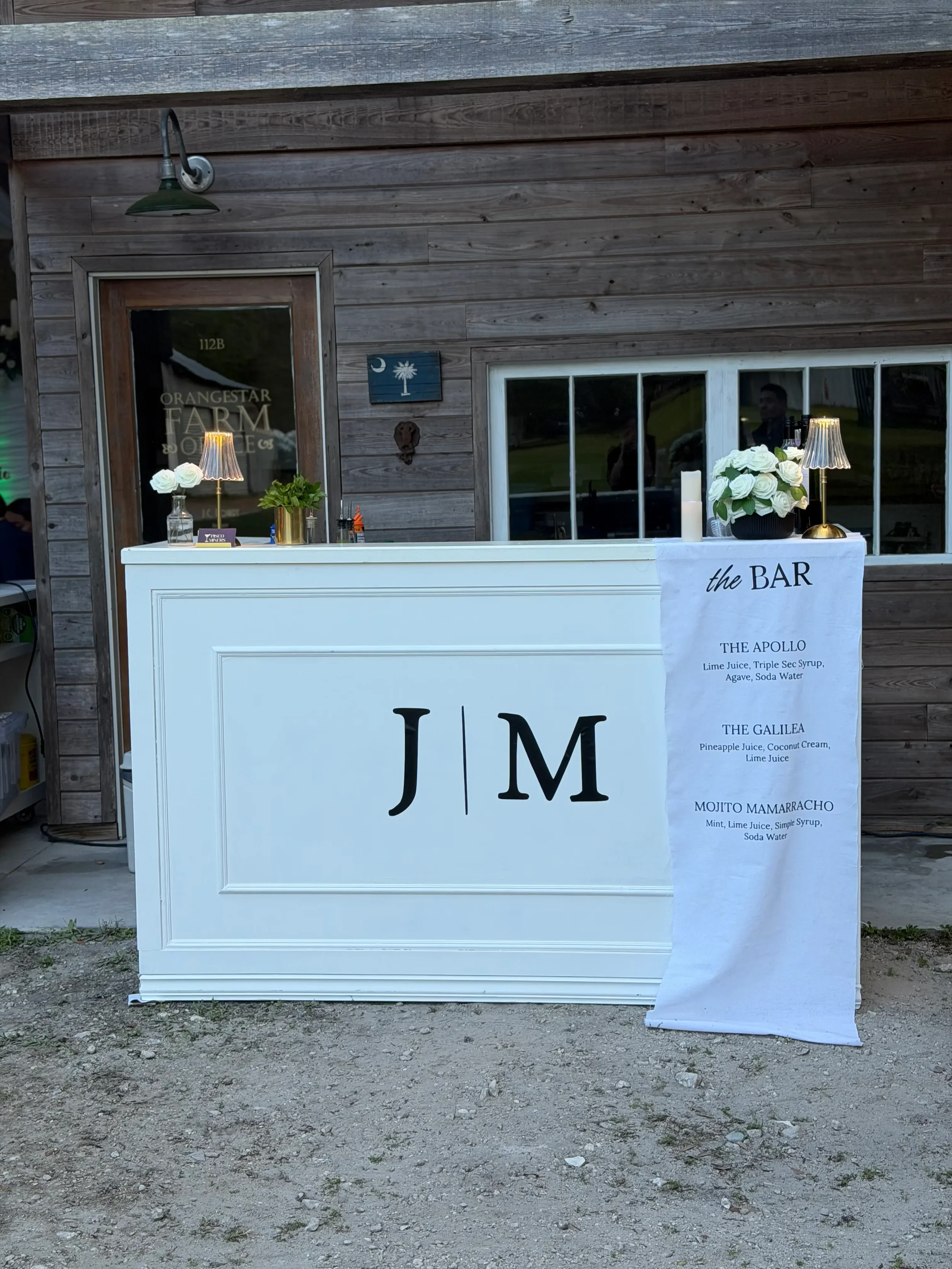 Luxury white mobile bar customized with the couple's initials, personalized menu, elegant décor, and premium branding details for a wedding celebration in Orlando.