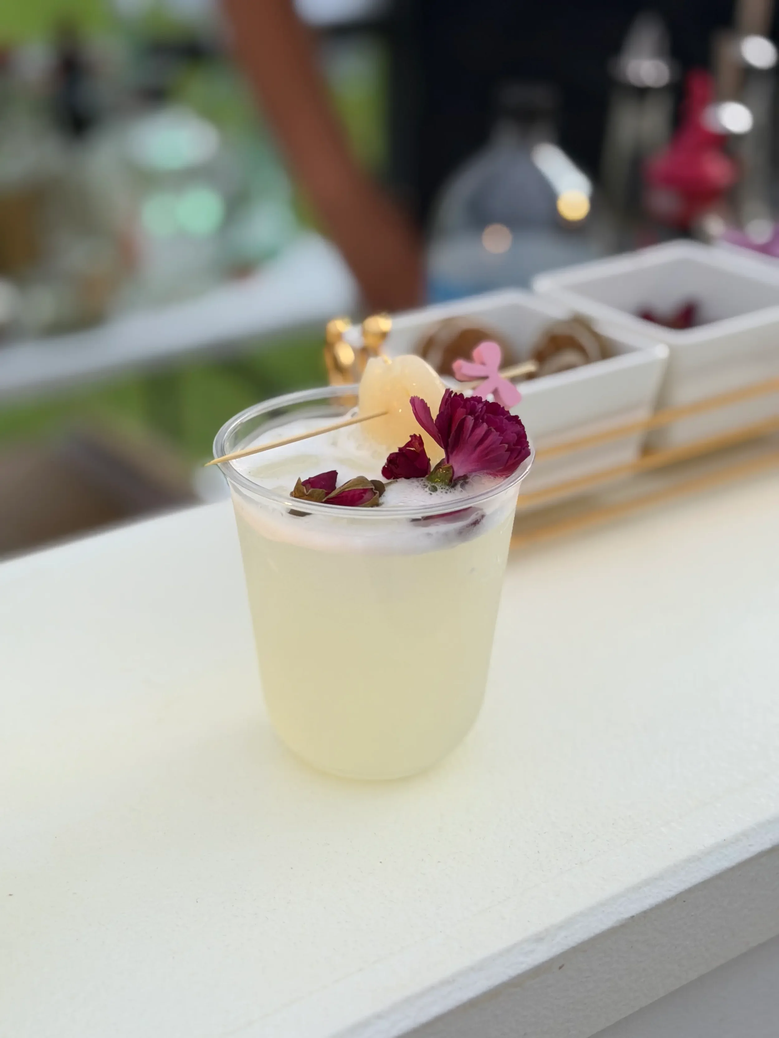 Signature lychee refresher cocktail crafted for a birthday celebration, featuring fresh lychee garnish, edible flowers, and a premium presentation by Pisco Mixers Mobile Bar in Orlando.