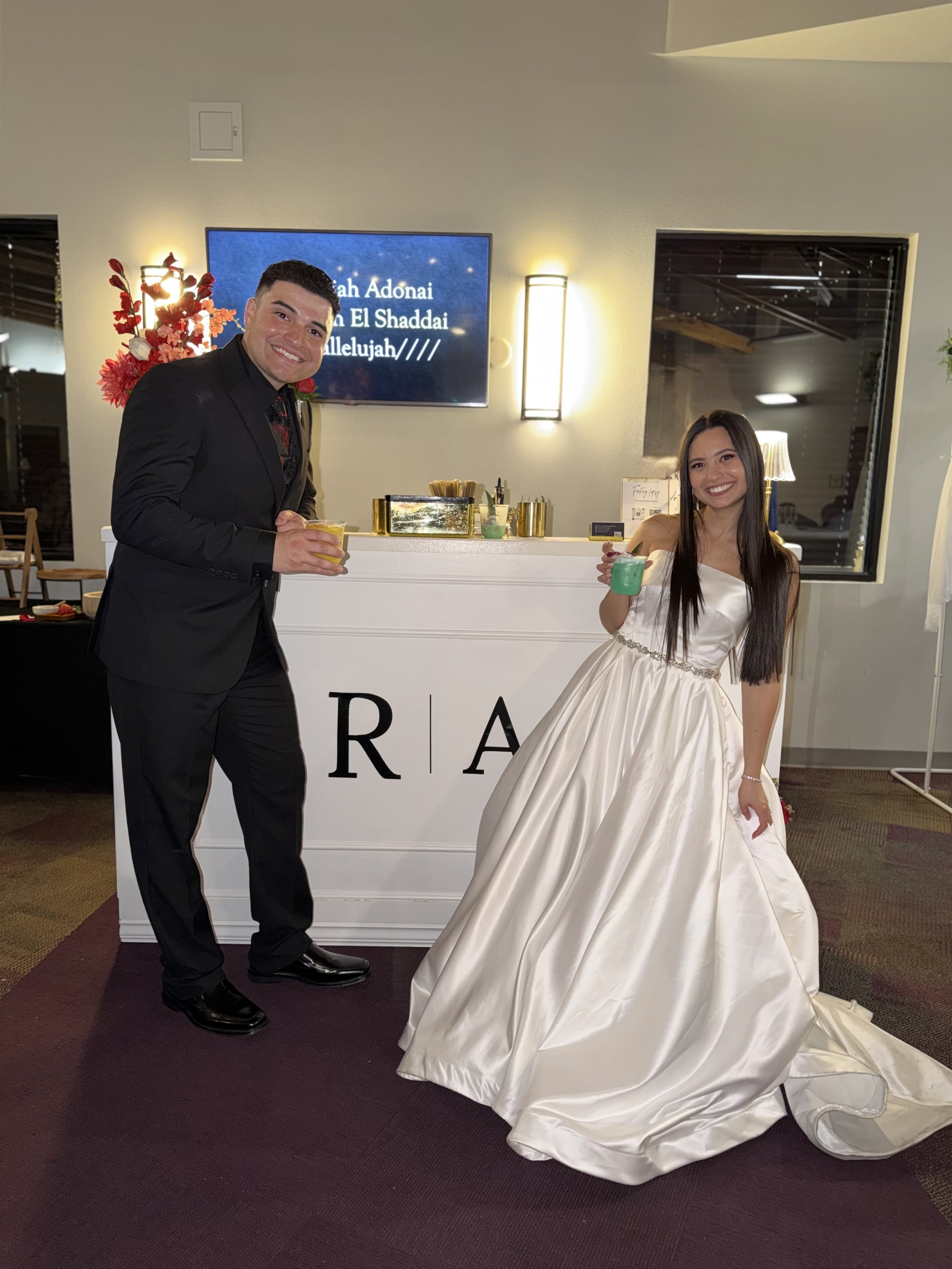 Couples who are recently married smiling at the camera holding their drinks