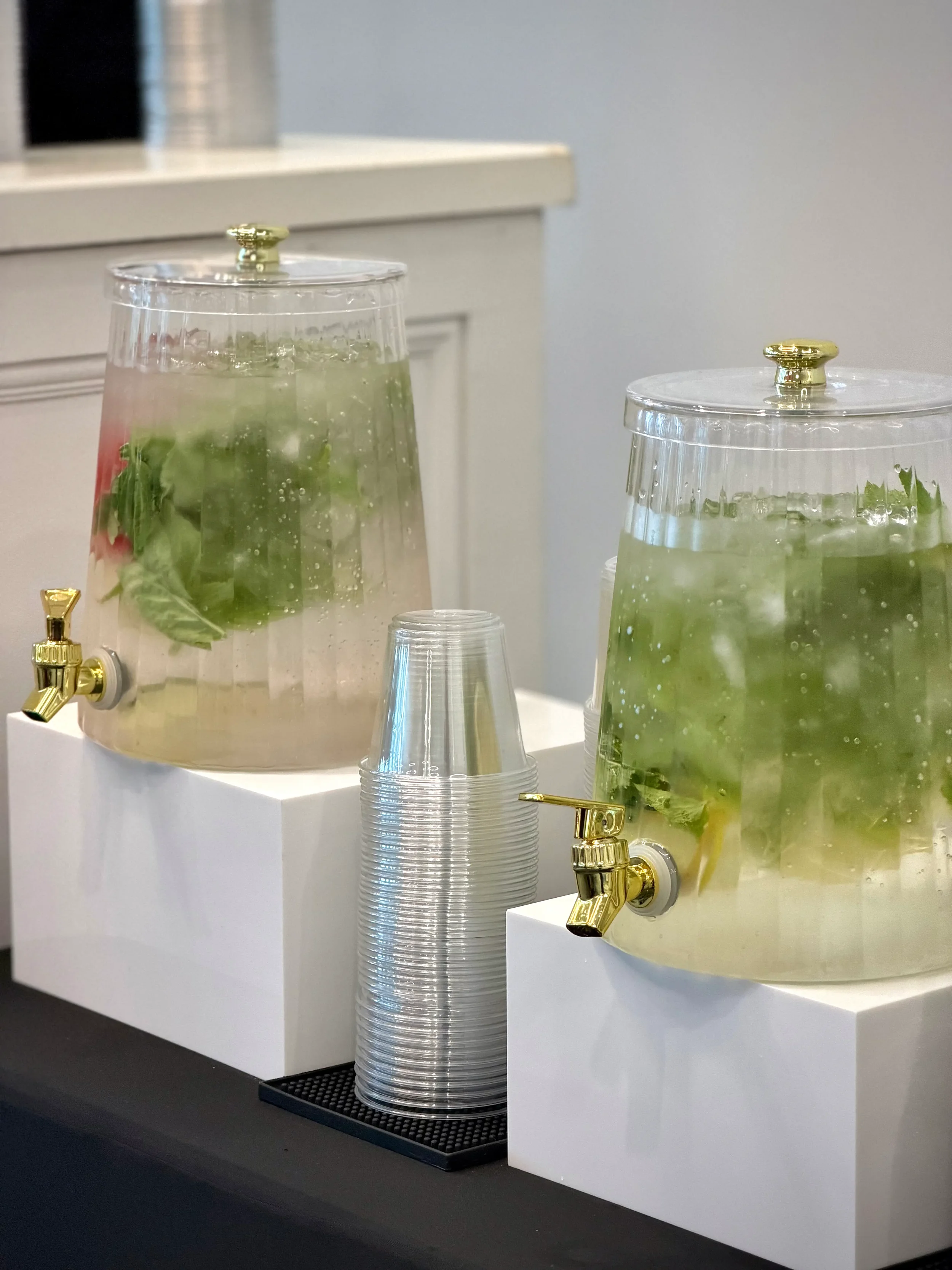 Luxury hydration station featuring infused water options, elegant beverage dispensers, cups, and a beautifully styled refreshment table for weddings, corporate events, and private celebrations by Pisco Mixers.