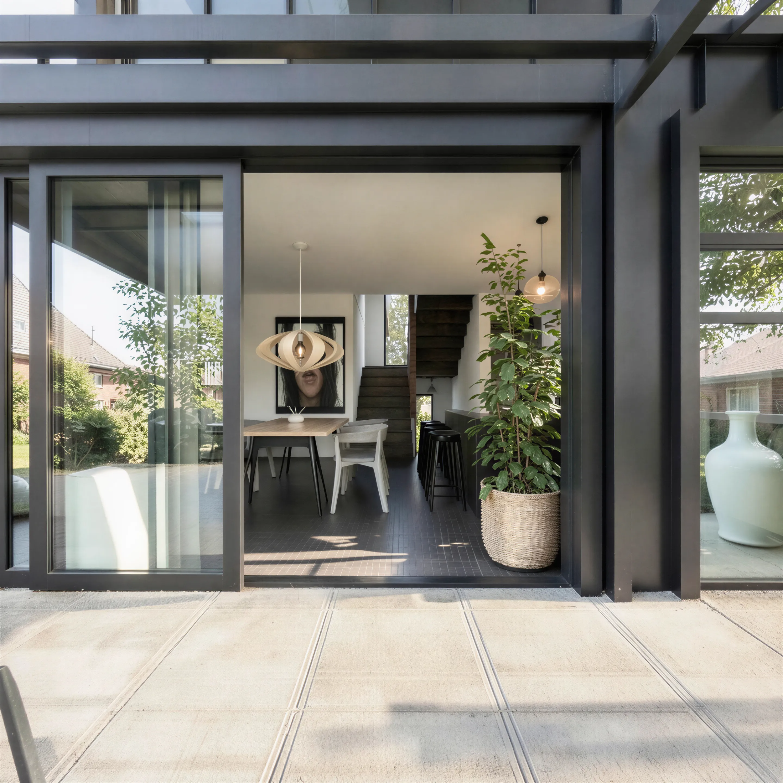 Living area with full height sliders opening to a private paved courtyard in an urban infill home
