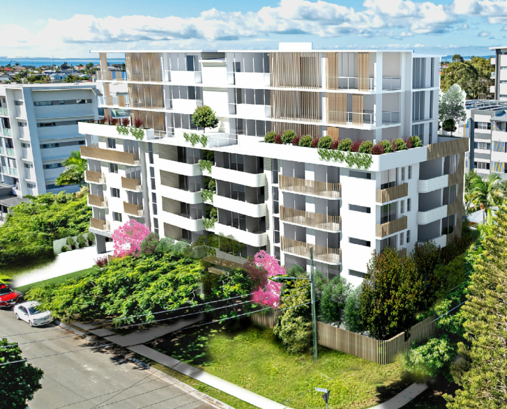 Modern multi-story apartment building with balconies, trees, and landscaping, in an urban area with other buildings and a partly cloudy sky.