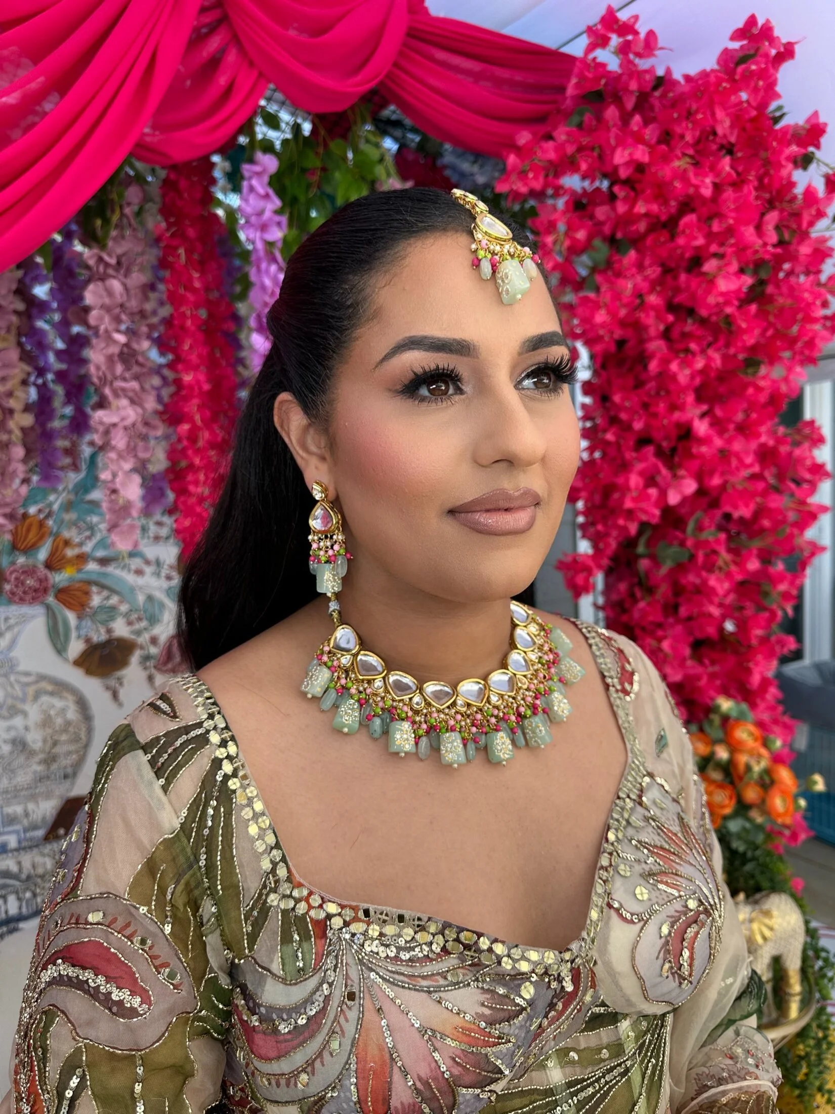 Occasion hair and makeup by Glam by Manpreet with a sleek ponytail and traditional jewelry.