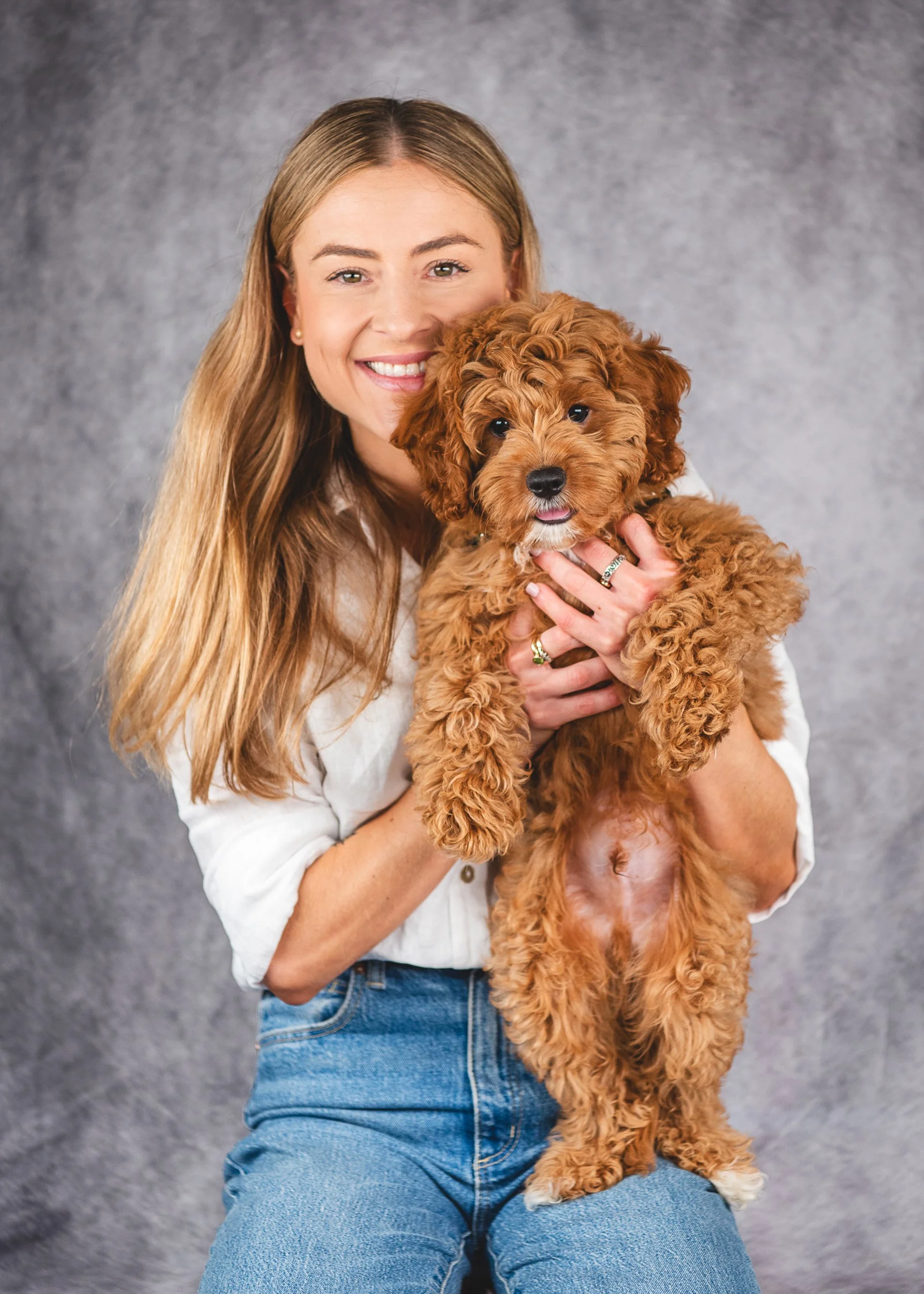 A proud dog mum cuddles her adorable Cavoodle puppy during their first professional pet photography session. Captured in our Gold Coast studio, this heartwarming portrait celebrates the excitement and joy of welcoming a new puppy into the family. PHO