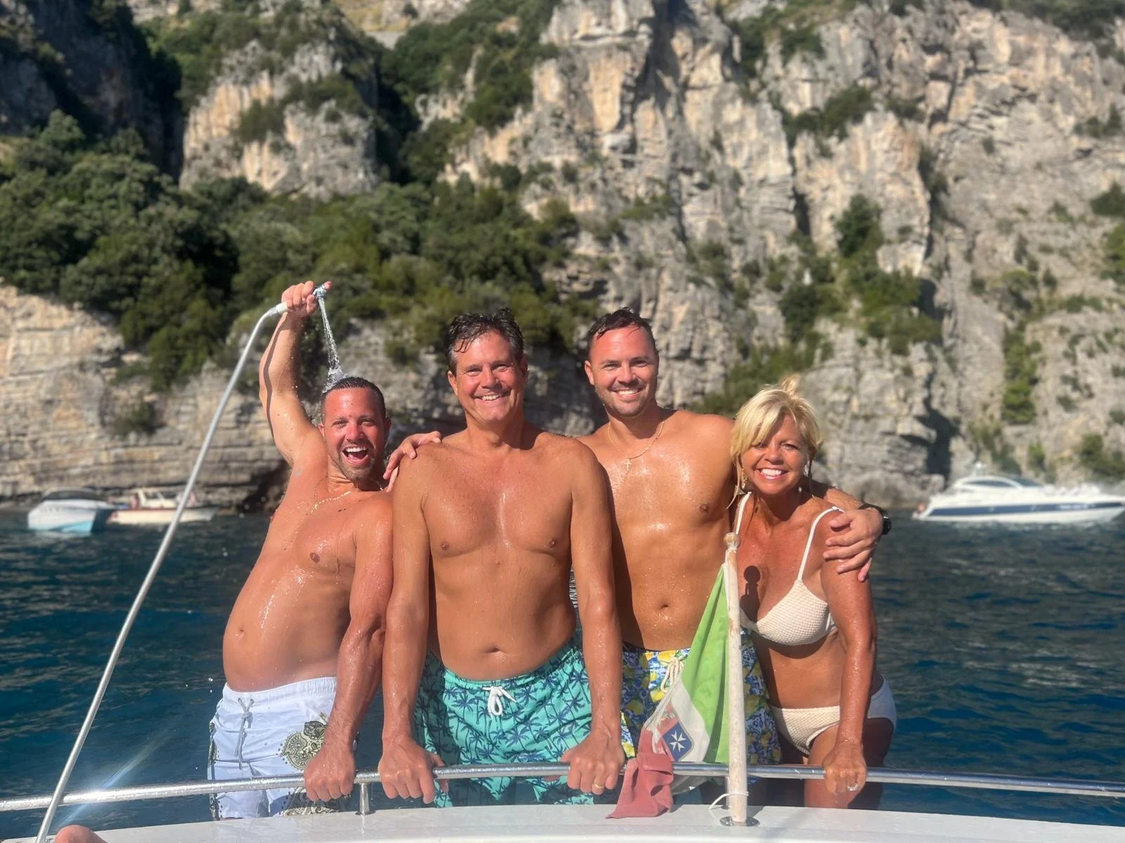 Four friends having fun and enjoying a sailboat ride on the beautiful Amalfi Coast