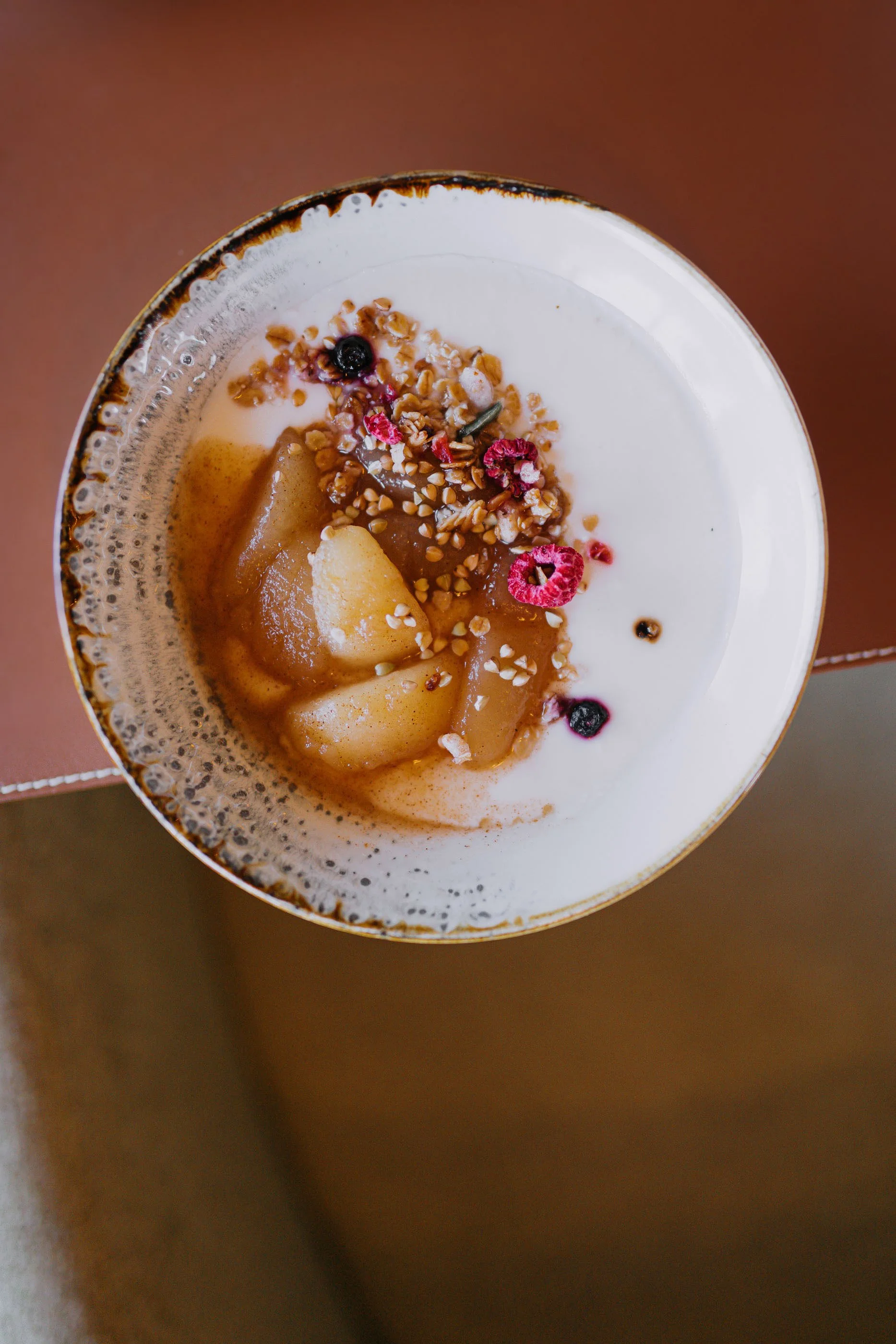 Nahaufnahme eines Drinks mit Granatapfelkernen, Früchten, Nüssen und Joghurt in einem Glas