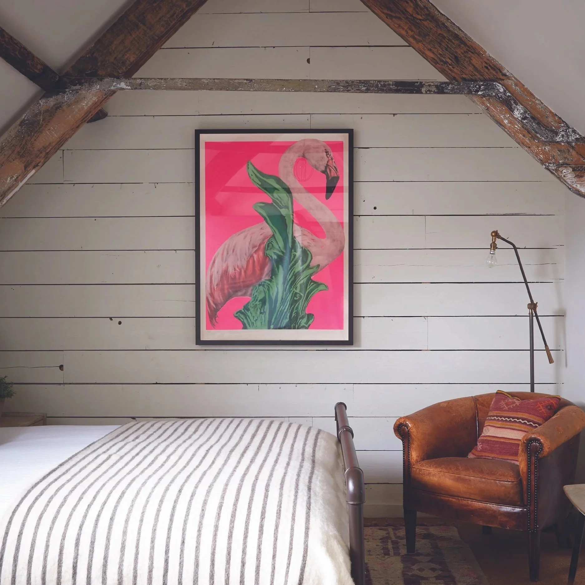 Artist Residence Penzance, full of playful Cornish character - exposed beams, soft stripes and a pop of pink flamingo charm tucked beneath the eaves.