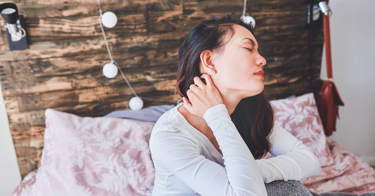 Woman with neck pain in bed