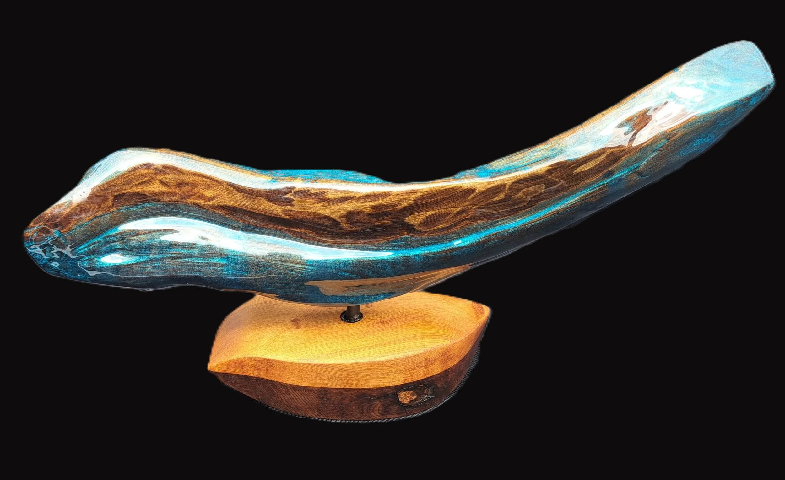 artistic wood and resin sculpture resembling a bird in flight, mounted on a wooden base