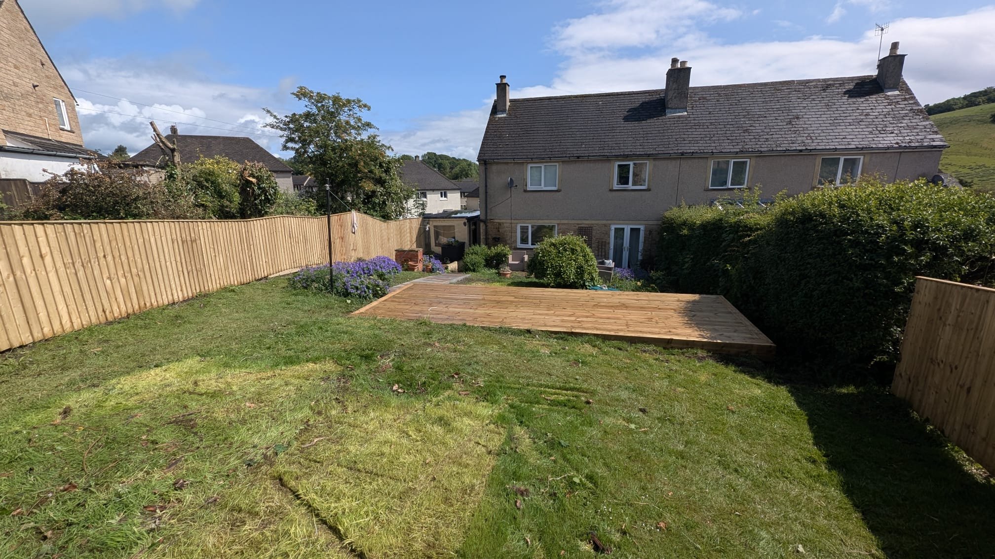 Small garden decking idea with built-in planters and privacy fencing